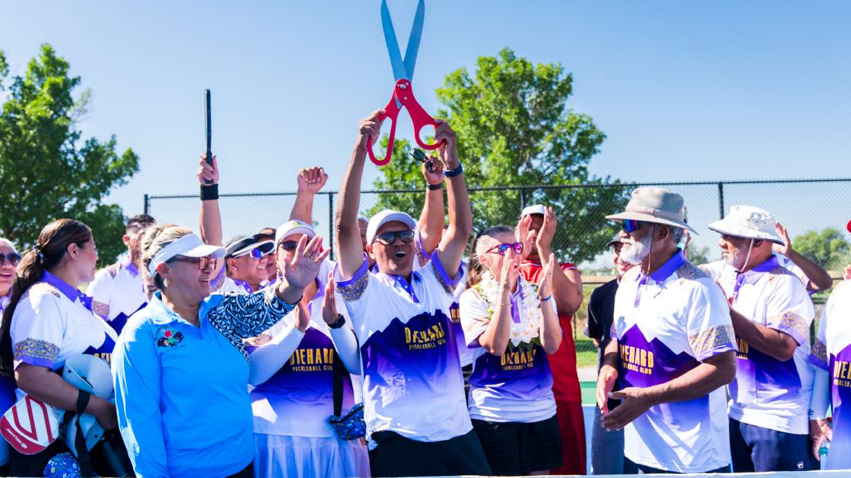 Ifa Motuliki holds ceremonial scissors up in the air after helping cut the ribbon to open 12 new pickleball courts at Glendale Regional Park in Salt Lake City on Saturday. More park elements are slated to open later this year.