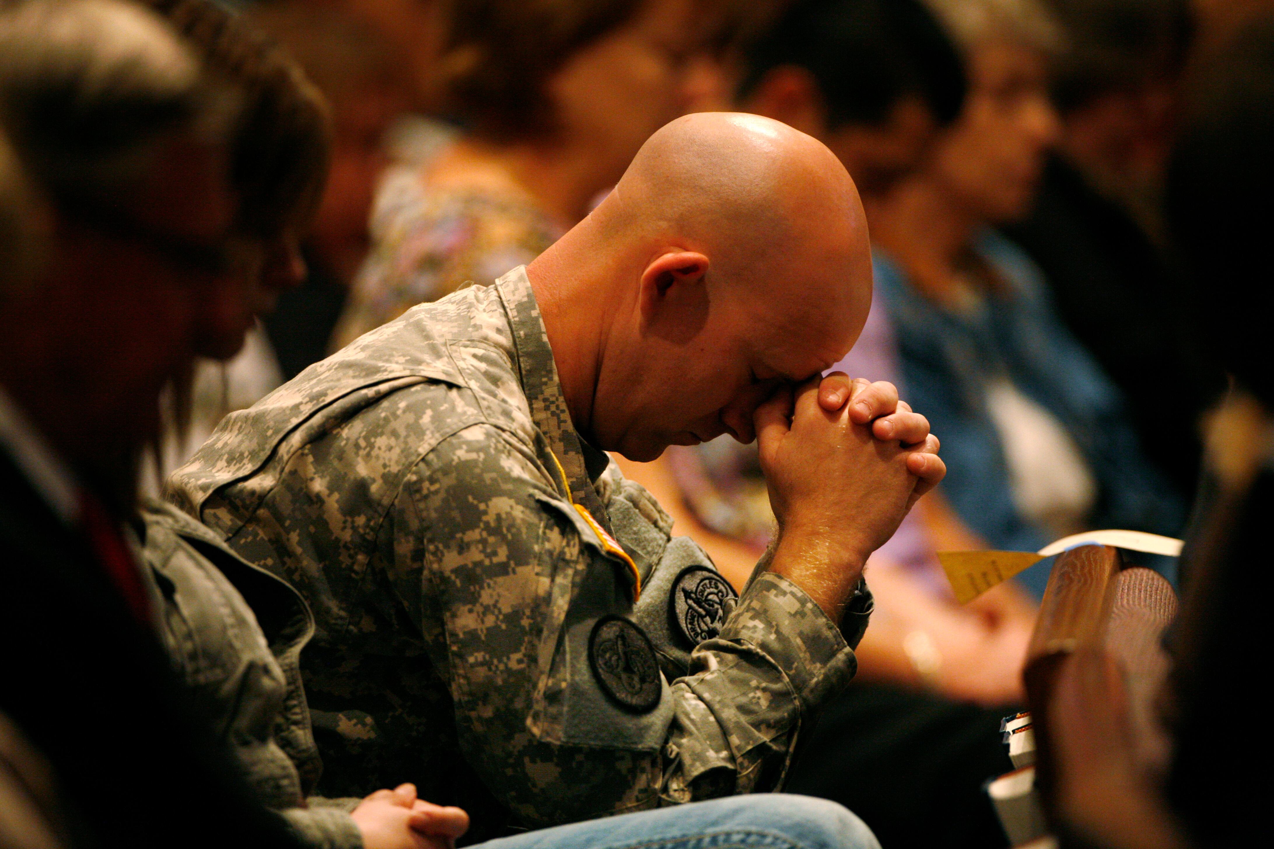 U.S. Army Sgt. Andrew Sobecky bows his head during the singing of "Amazing Grace," during a prayer service at First Baptist Church, Nov. 8, 2009, in Killeen, Texas.