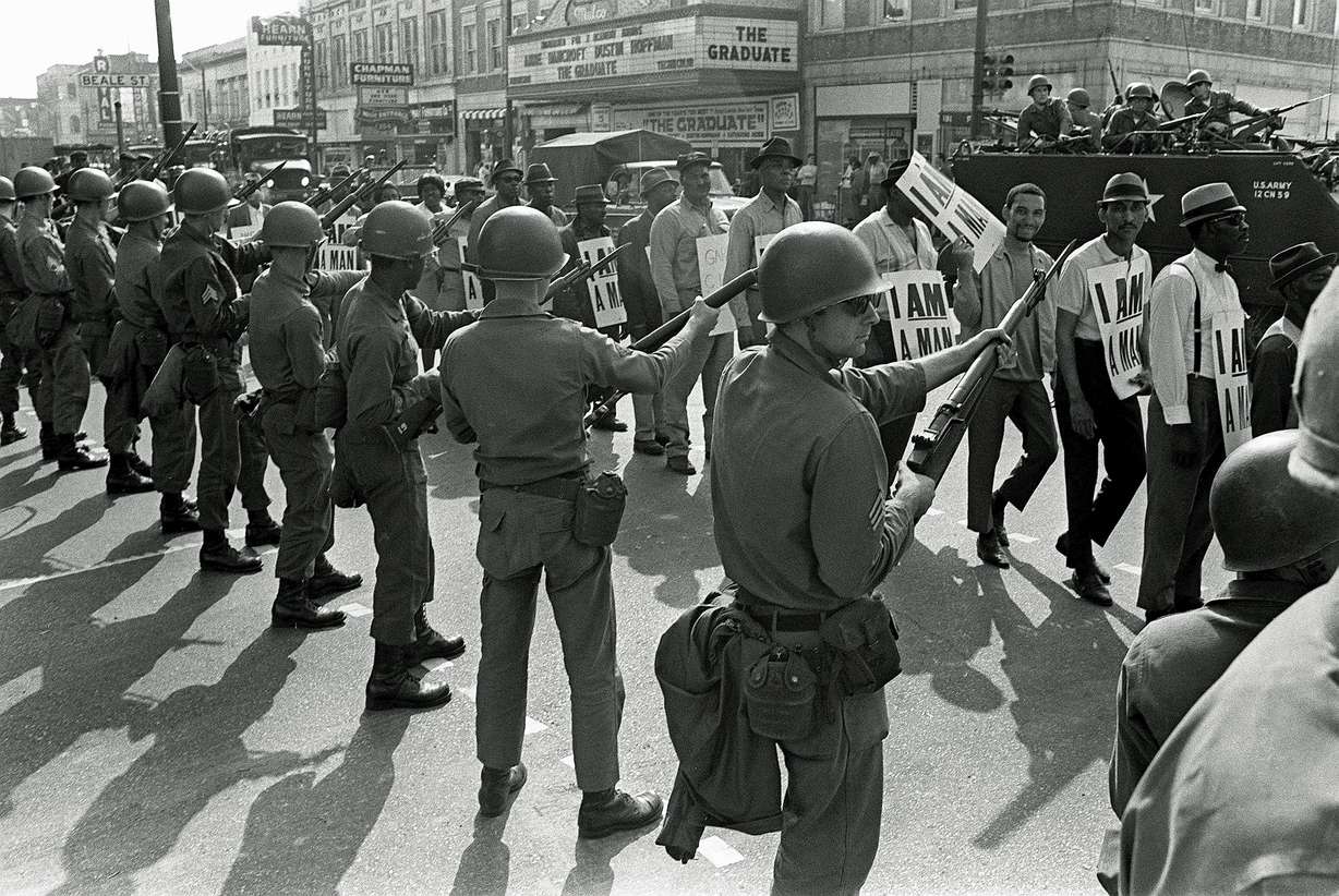 In this March 29, 1968, file photo, striking sanitation workers march past Tennessee National Guard troops with bayonets during a 20-block march to City Hall, one day after a similar march erupted in violence, leaving one person dead and several injured, in Memphis, Tenn.
