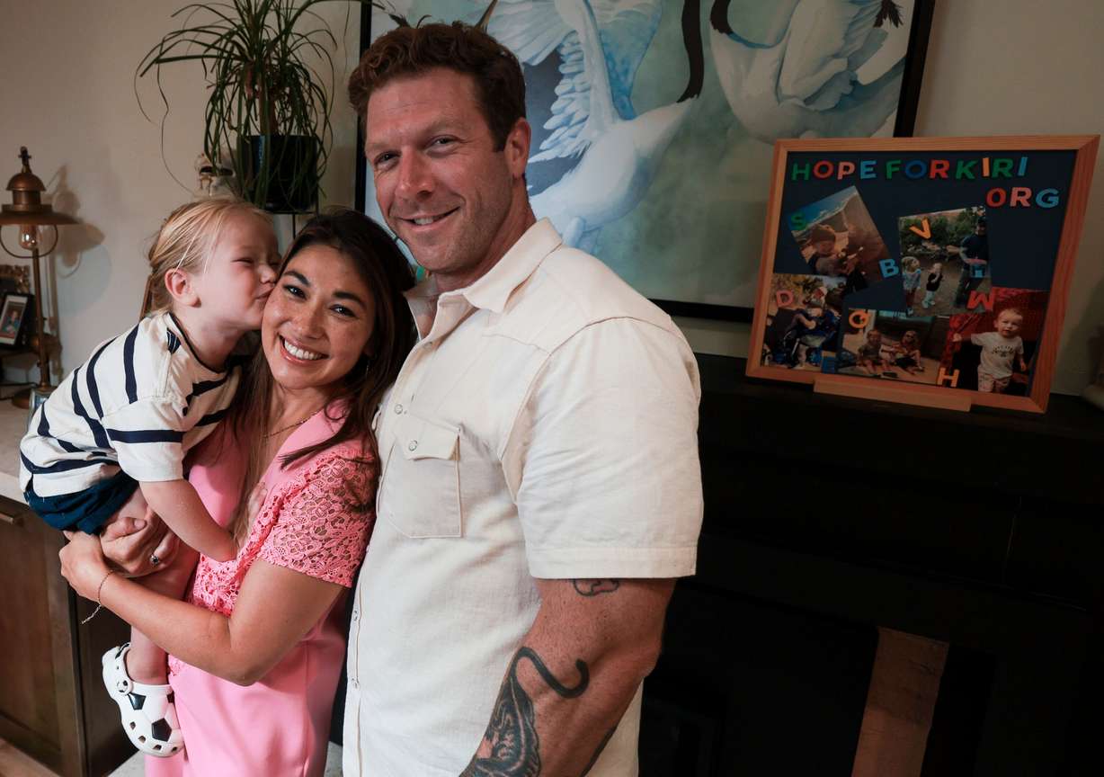 Jazmynn Pok gets a kiss from her son, Kiri, 3, as her husband Anthony Duke-Rosati stands next to her at their Holladay home on Monday. Doctors told the family that the deadline to start Kiri's treatment is Sept. 8.