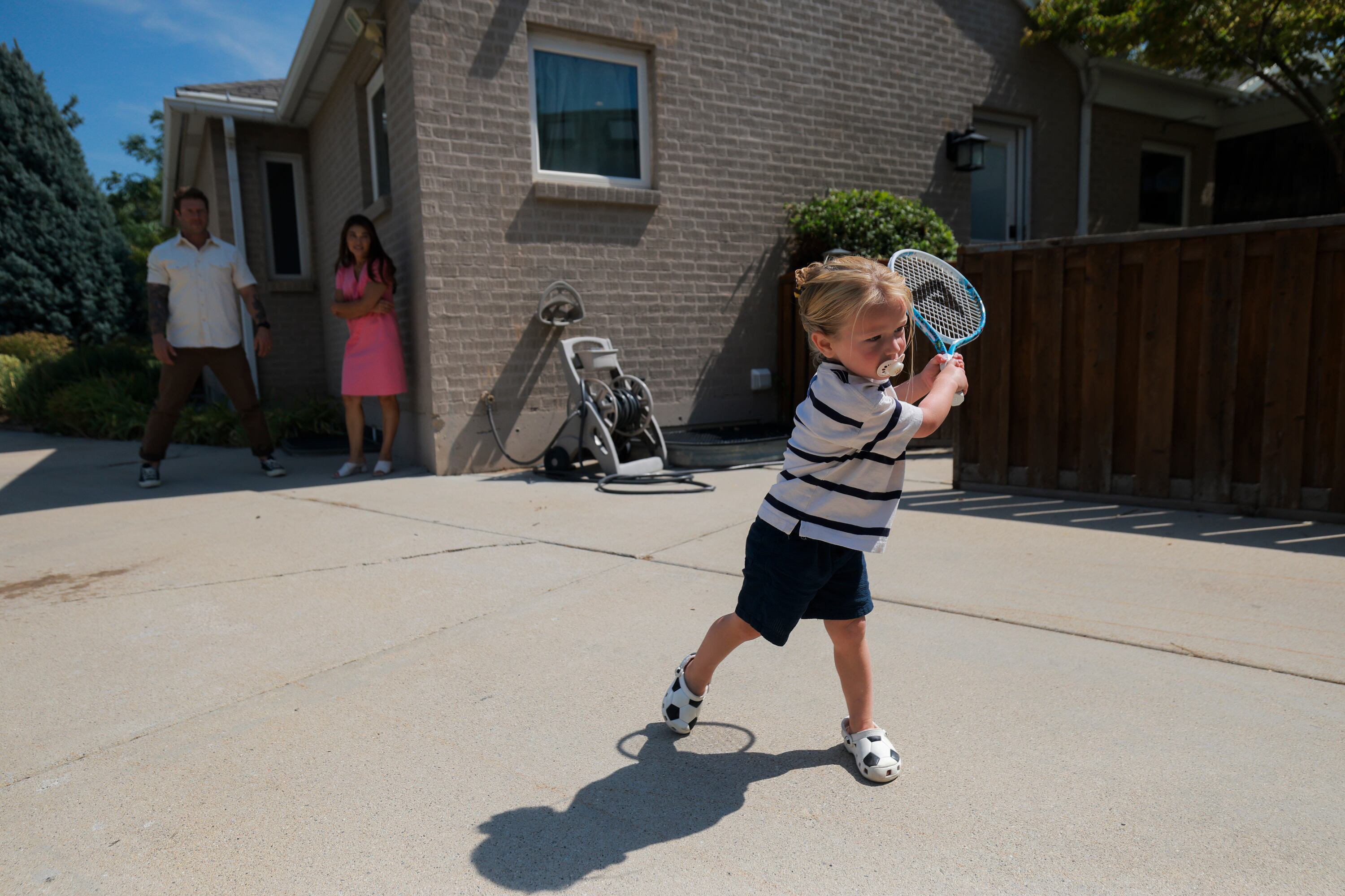 Kiri Duke-Rosati, 3, plays tennis against the garage door at his Holladay home on Monday. Duke-Rosati is very close to his siblings.