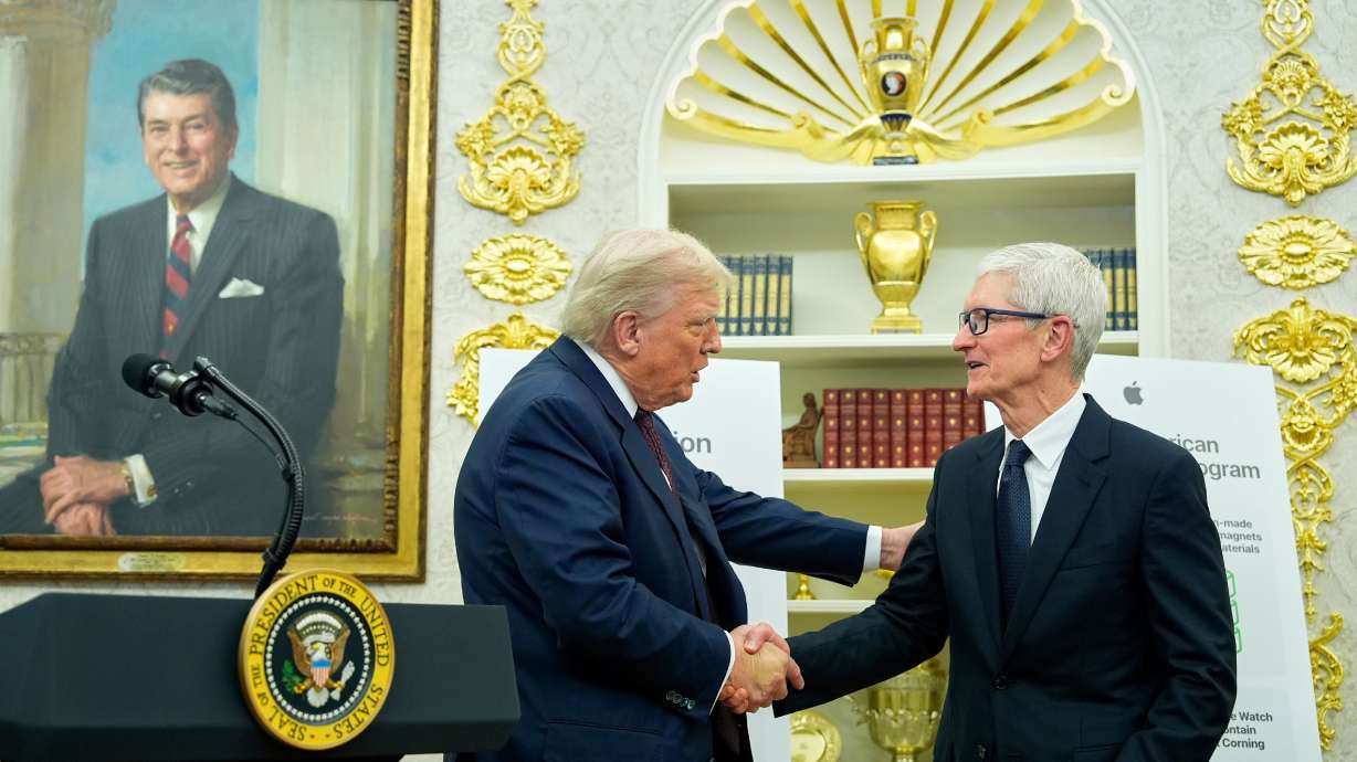 President Donald Trump shakes hands with Apple CEO Tim Cook in the Oval Office, Wednesday, in Washington. Apple plans to increase its commitments to investments in domestic manufacturing facilities by $100 billion.