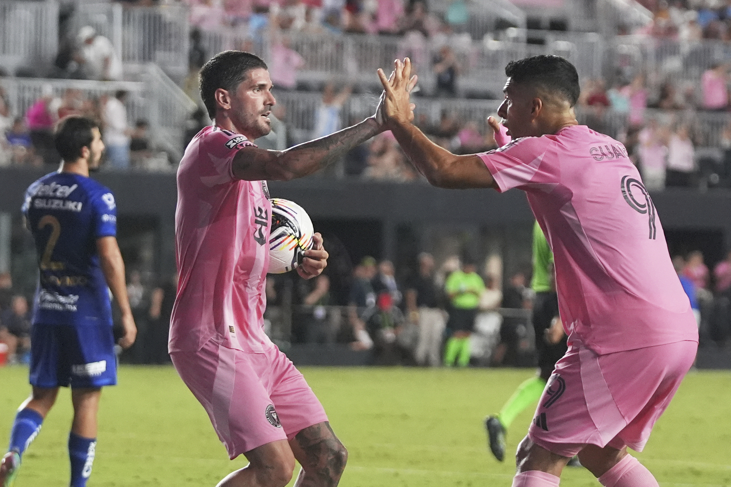 Inter Miami midfielder Rodrigo De Paul, left celebrates with forward Luis Suárez (9) after scoring a goal during the first half of a Leagues Cup soccer match against Puma UNAM, Wednesday, Aug. 6, 2025, in Fort Lauderdale, Fla.