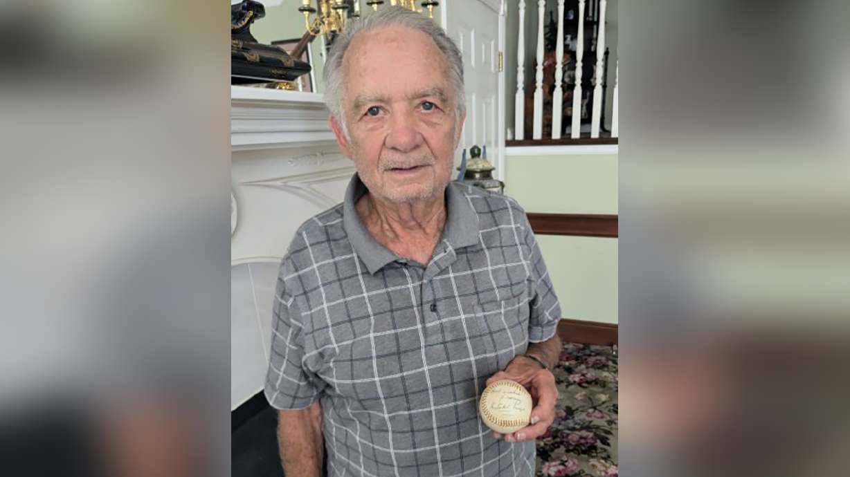Gordon Loveless holds his baseball autographed by Satchel Paige, Baseball Hall of Famer and Negro Leagues great. Paige signed the ball with a message that reads "Best wishes from Satchel Paige."