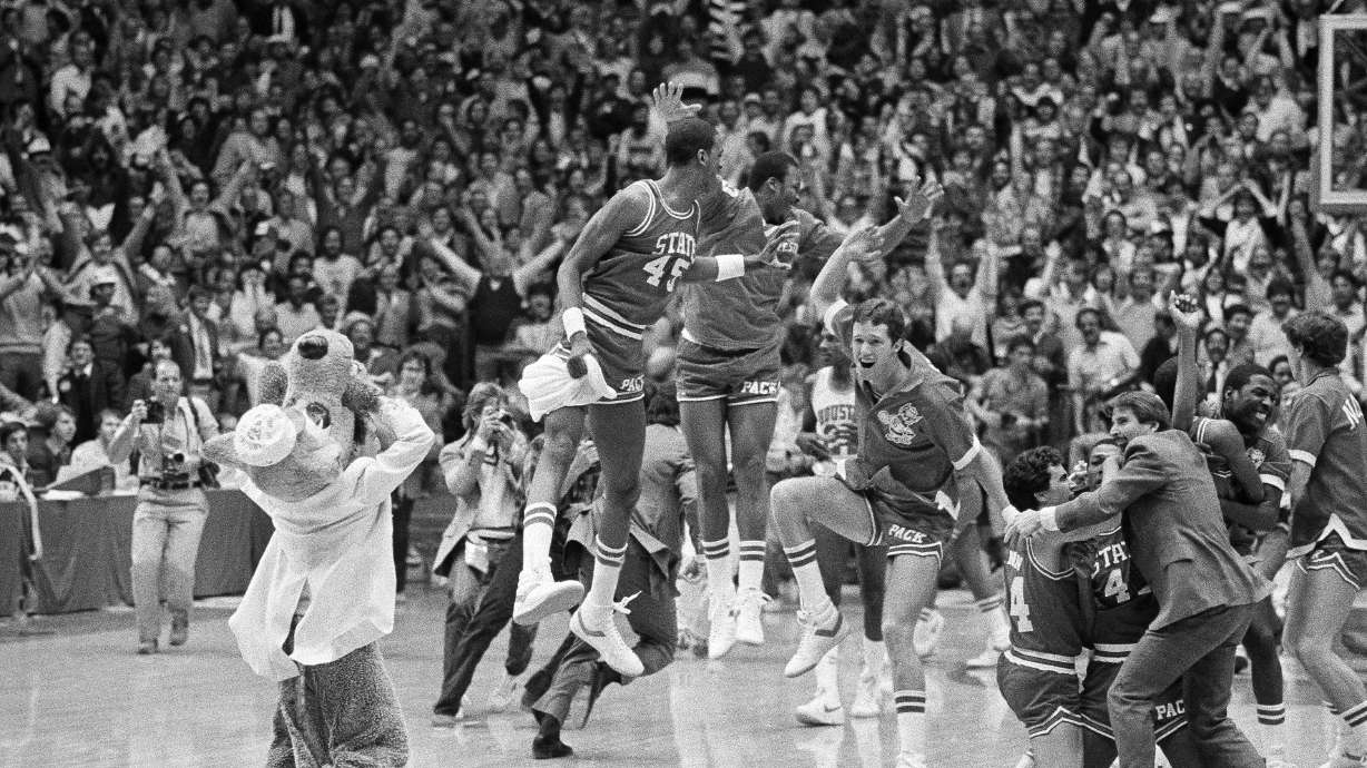 FILE - In this April 4, 1983, file photo, a high jumping Cozell McQueen (45), left center, and teammates celebrate defeating Houston 54-52 in the NCAA college basketball championship game in Albuquerque, N.M.