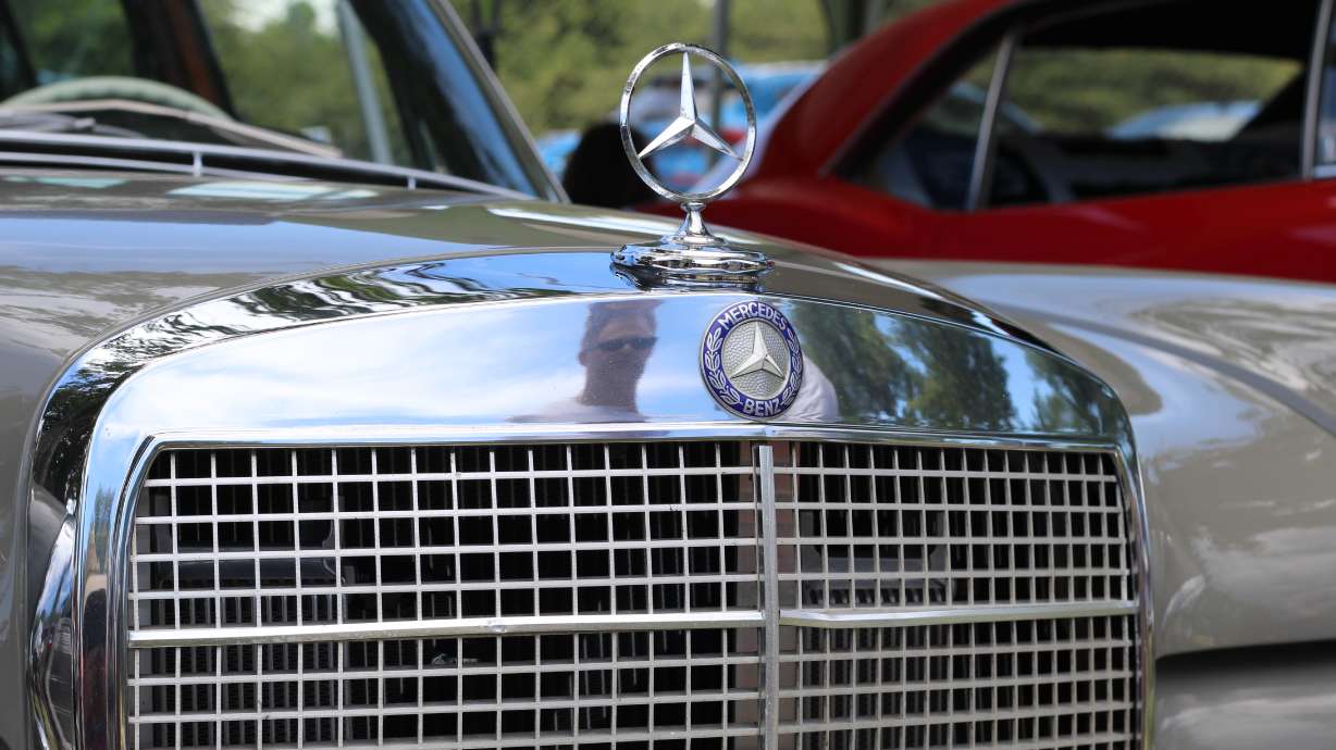 Alex Hixson is reflected in the chrome detail of his 1971 Mercedes 280 SE at the 2024 Cache Cruise-In.