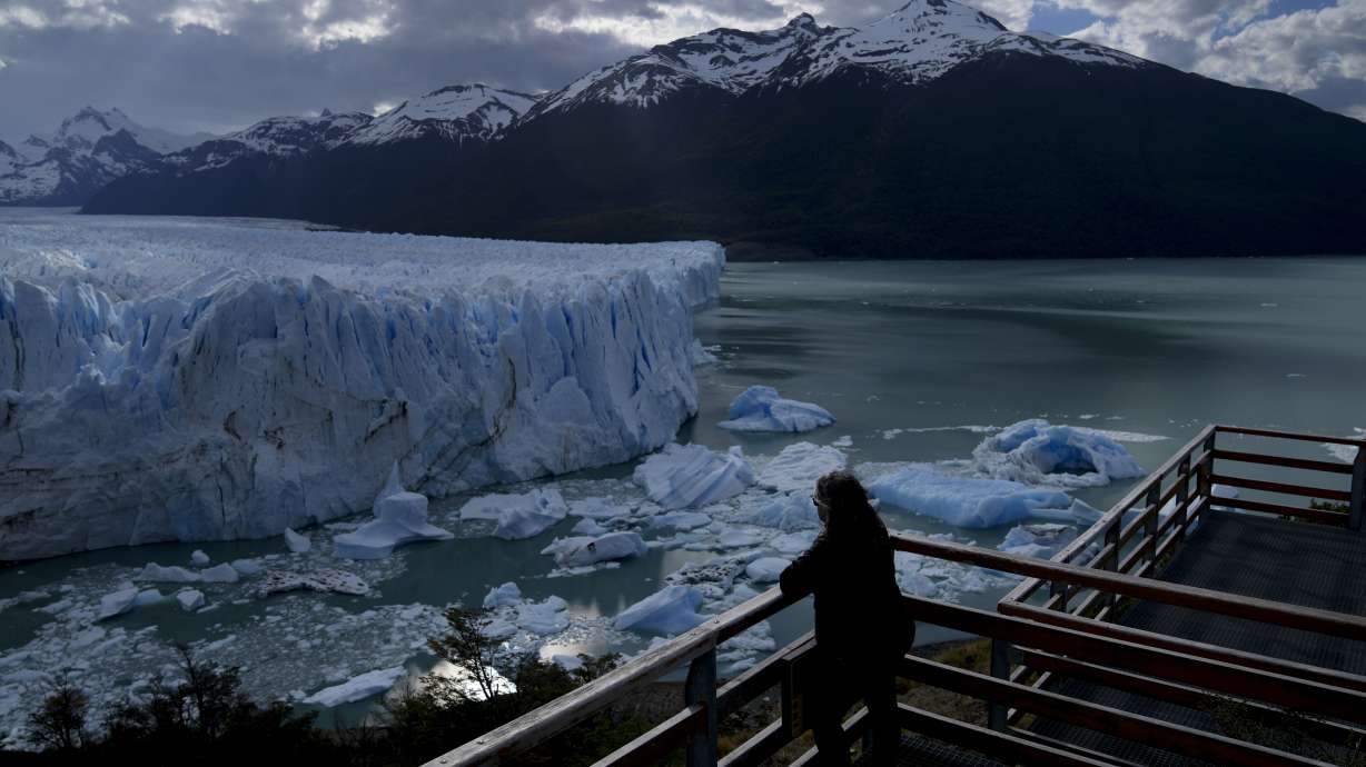 A tourist watches the Perito Moreno Glacier at Los Glaciares National Park, near El Calafate, Argentina, Nov. 1, 2021.
