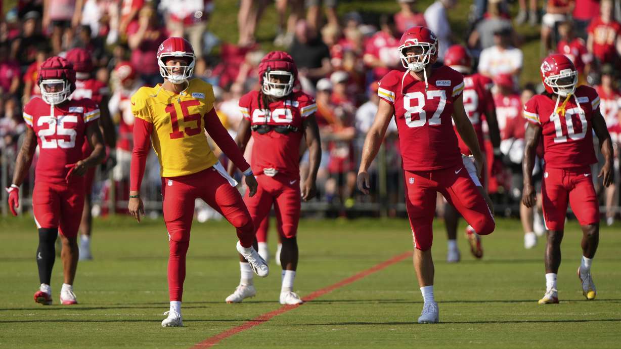 Kansas City Chiefs quarterback Patrick Mahomes (15) and tight end Travis Kelce (87) stretch with teammates at NFL football training camp Tuesday, Aug. 5, 2025, in St. Joseph, Mo.