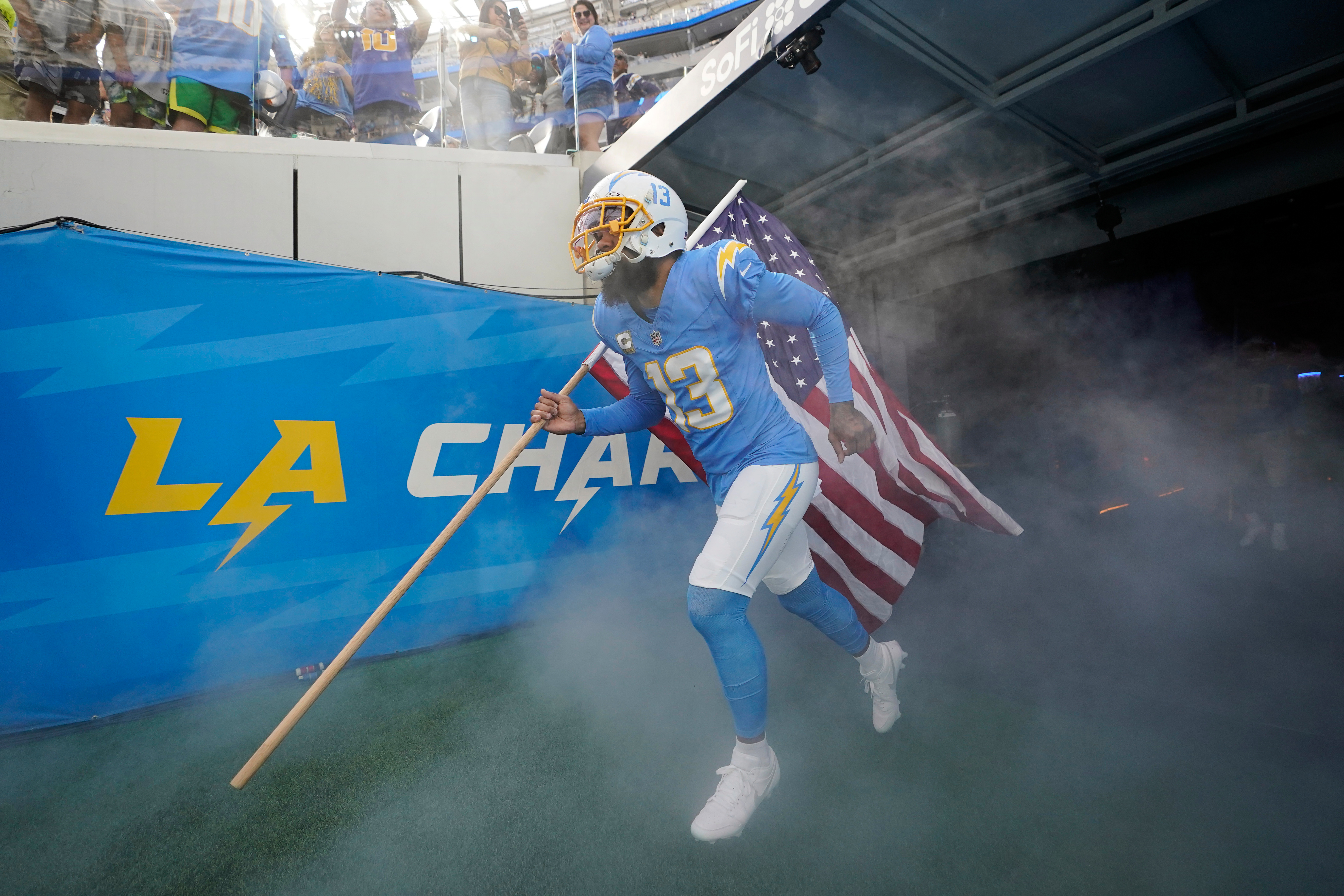 FILE - Los Angeles Chargers wide receiver Keenan Allen carries a United States flag as he is introduced before an NFL football game against the Detroit Lions, Nov. 12, 2023, in Inglewood, Calif.