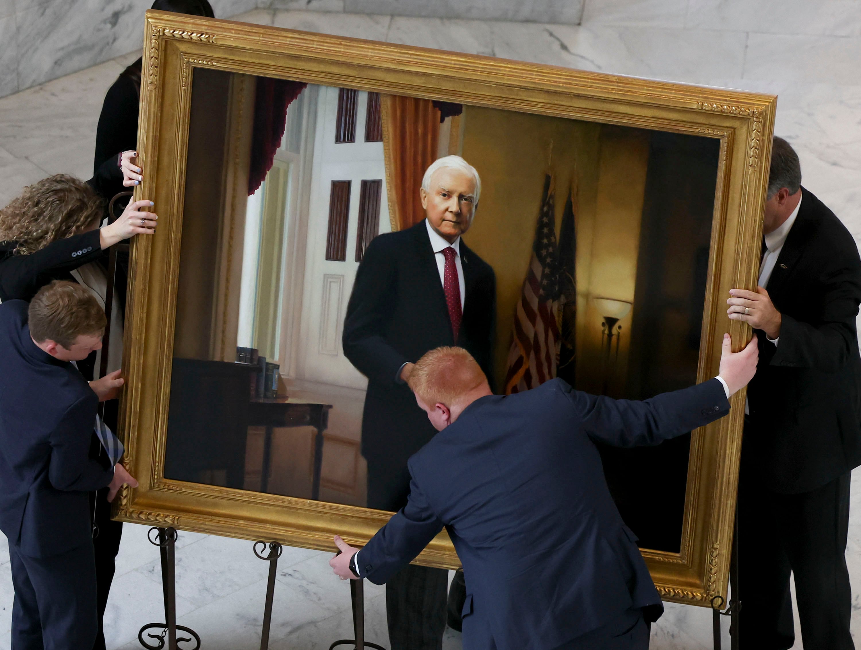 Larkin Mortuary staff members position a painting of former Sen. Orrin Hatch prior to a public viewing at the Capitol in Salt Lake City, May 4, 2022.