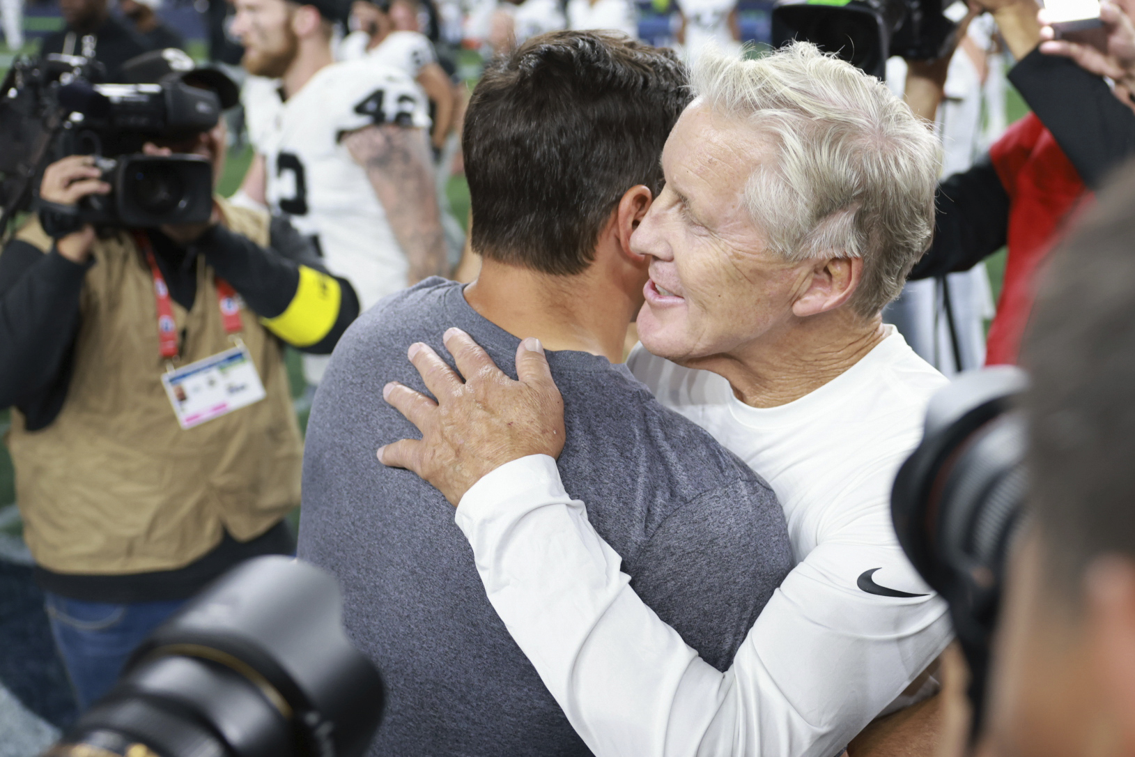Seattle Seahawks head coach Mike Macdonald, left, hugs Las Vegas Raiders head coach Pete Carroll after an NFL preseason football game Thursday, Aug. 7, 2025, in Seattle.