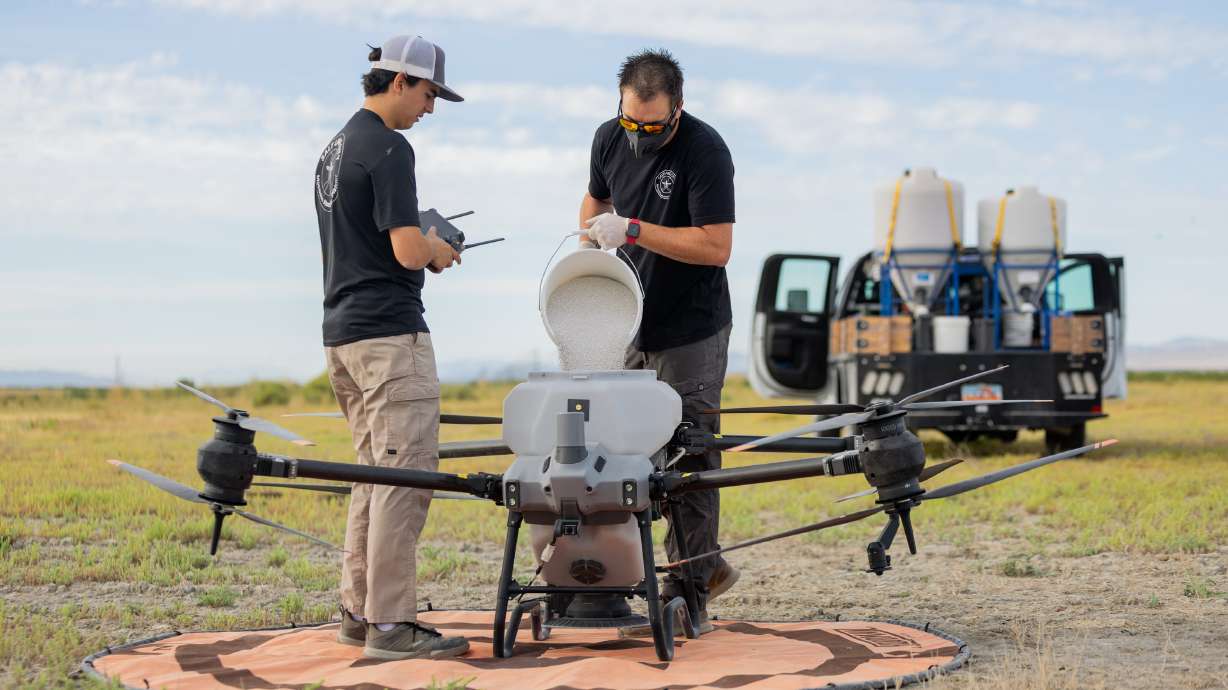 Brad Sorensen pours Natular G30 into a drone controlled by Sam Wilson in Salt Lake City on Friday. The operation is part of an amped up effort to defend communities against mosquitoes, particularly West Nile virus.