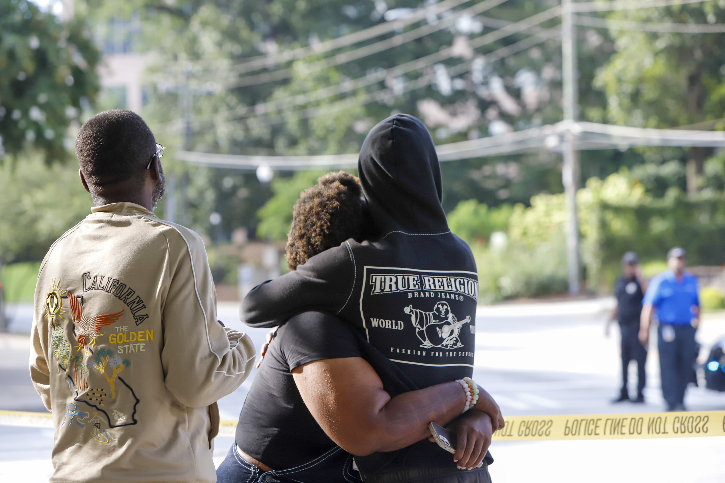 Bystanders after a shooting near the campuses of the Centers for Disease Control and Prevention and Emory University, Friday, in Atlanta. Police said the shooter and a police officer are dead following their response.