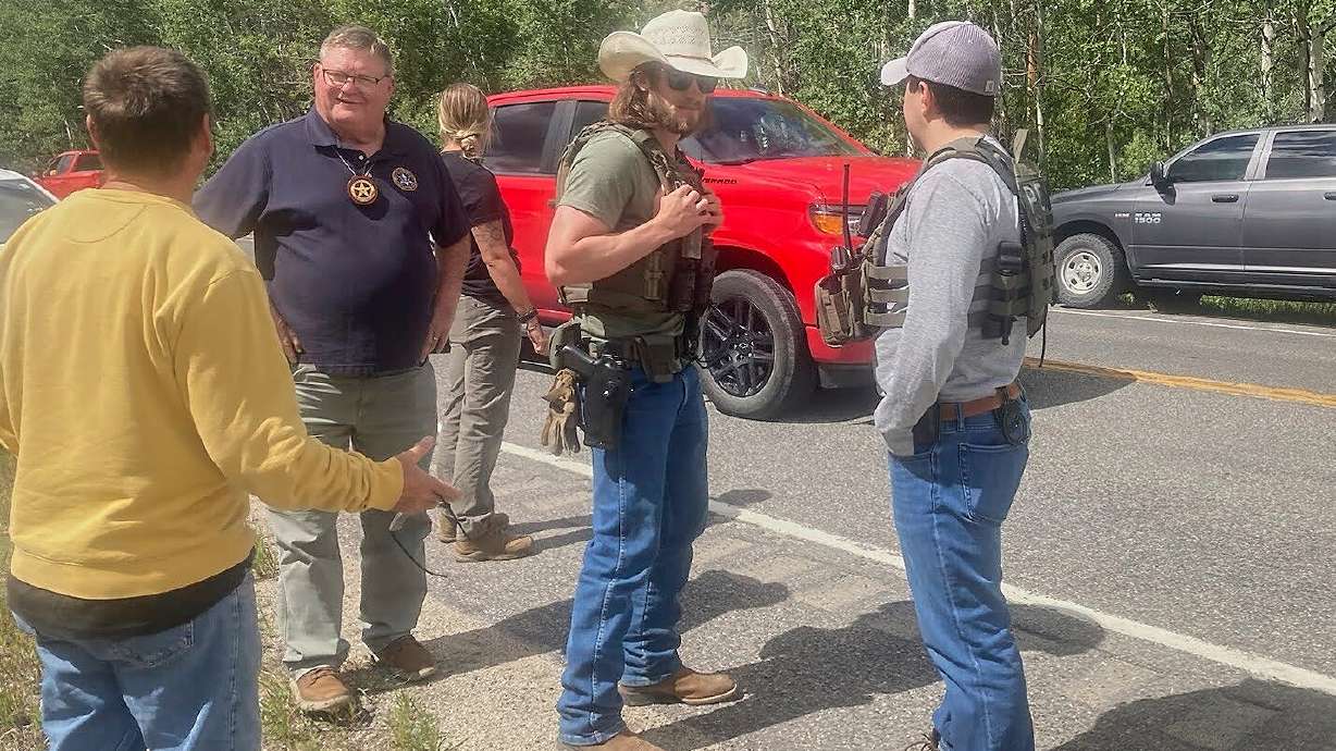 Law enforcement officers stand at the scene where Michael Brown, a suspect in a shooting at a Montana bar that left four people dead, was apprehended on Friday, outside of Anaconda, Mont.
