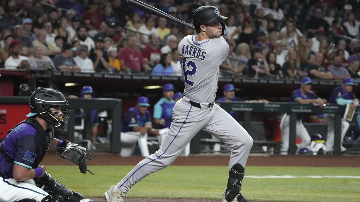 Colorado Rockies' Kyle Karros hits an RBI single on his major league at-bat debut against the Arizona Diamondbacks in the second inning of a baseball game, Friday, Aug. 8, 2025, in Phoenix.