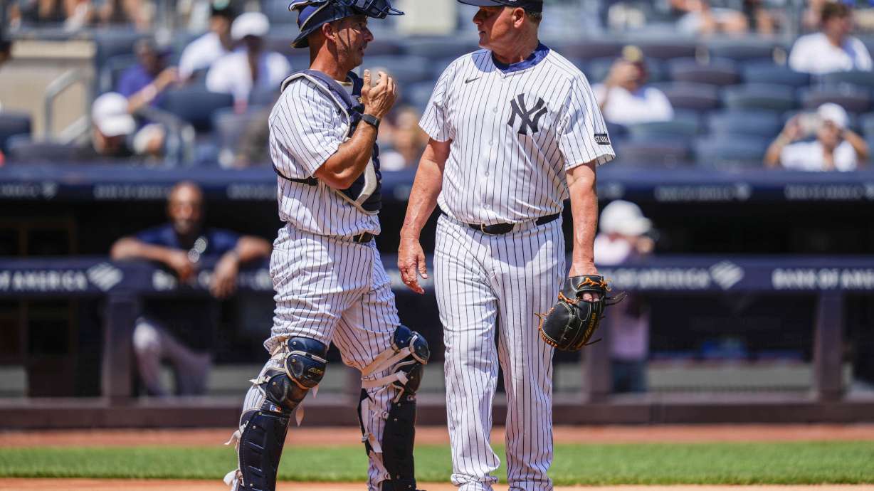 Former New York Yankees' Roger Clemens (22) and Jorge Posada (20) speak during the first inning of the Yankees Old-Timers' Day Game before a baseball game against the Houston Astros, Saturday, Aug. 9, 2025, in New York.