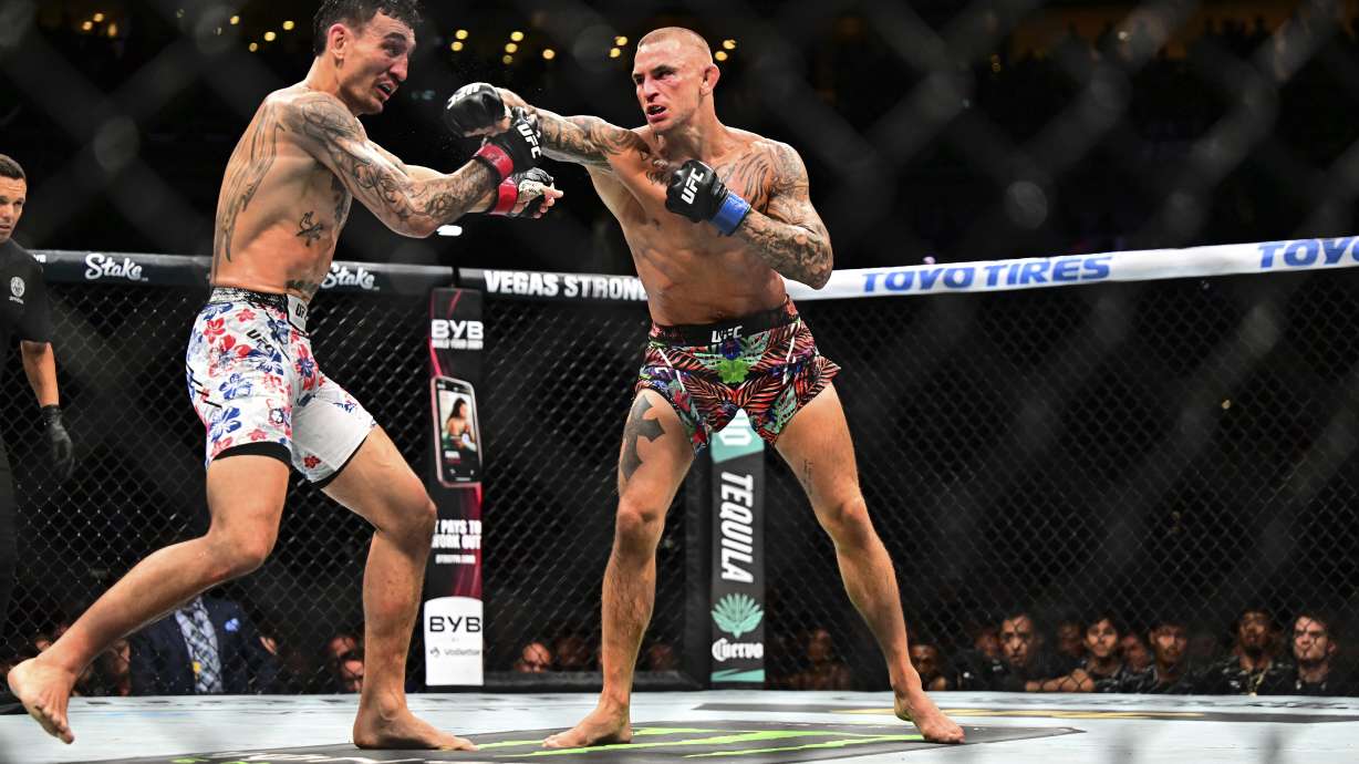 Dustin Poirier, right, hits Max Holloway in a lightweight title fight at UFC 318 in New Orleans, La., Saturday, July 19, 2025.