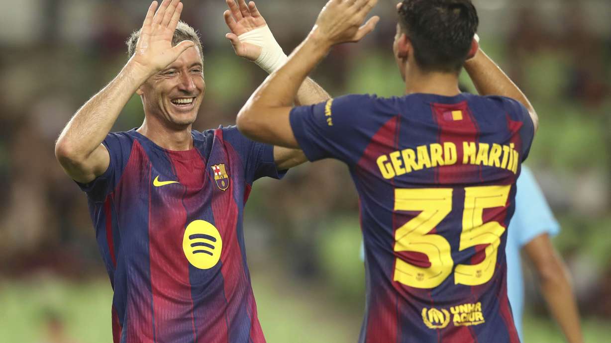 FC Barcelona's Robert Lewandowski, left, celebrates with his teammate Gerard Martin after scoring a goal during a friendly soccer match between FC Barcelona and Daegu FC at the Daegu Stadium in Daegu, South Korea, Monday, Aug. 4, 2025.