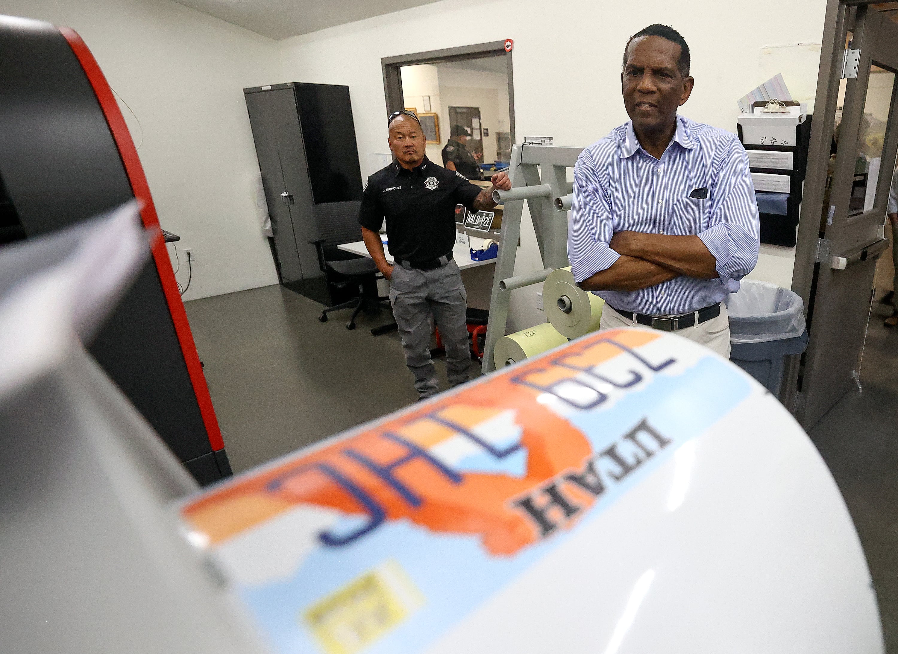 Rep. Burgess Owens, R-Utah, looks at a roll of recently printed license plates, made by Utah State Correctional Facility inmates, while touring the Utah Correctional Industries building at the Utah State Correctional Facility in Salt Lake City, Aug. 4.