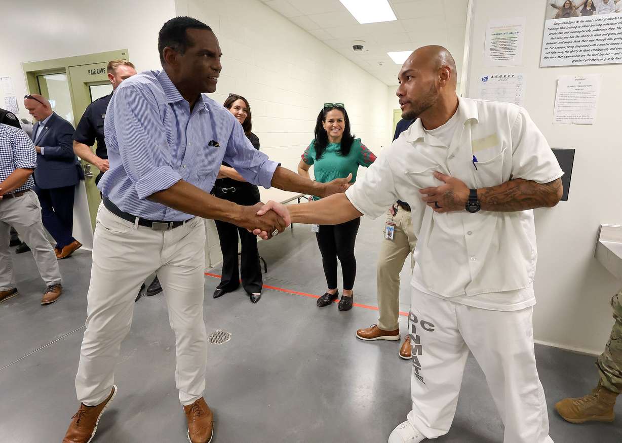 Rep. Burgess Owens, R-Utah, shakes hands with Alfredo Lolani, an inmate and certified peer support specialist, in the Bear 2 building while Owens tours the Utah State Correctional Facility in Salt Lake City, Aug. 4.