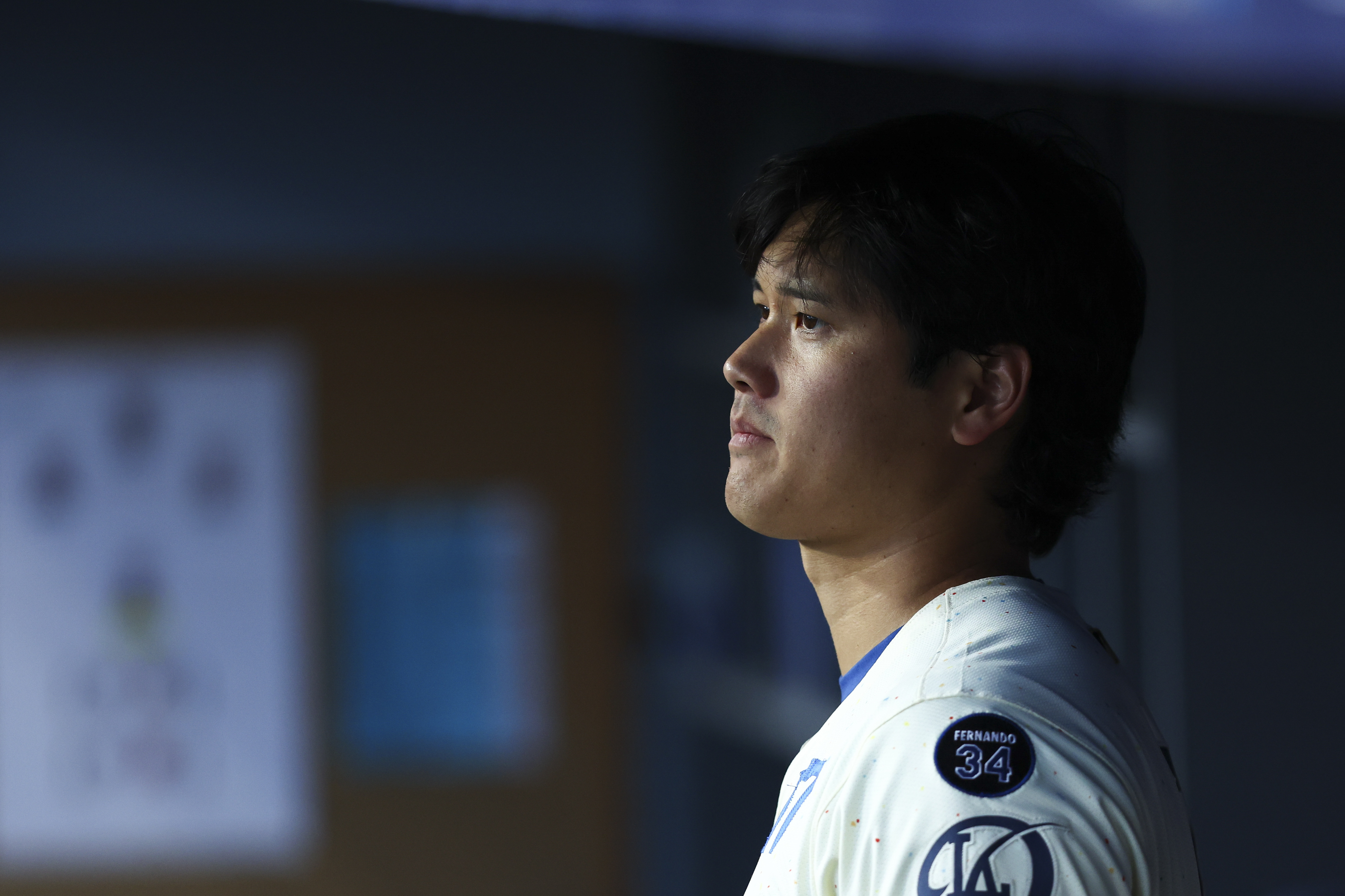 Los Angeles Dodgers' Shohei Ohtani looks on in the dugout during the fifth inning of a baseball game against the Toronto Blue Jays, Saturday, Aug. 9, 2025, in Los Angeles.