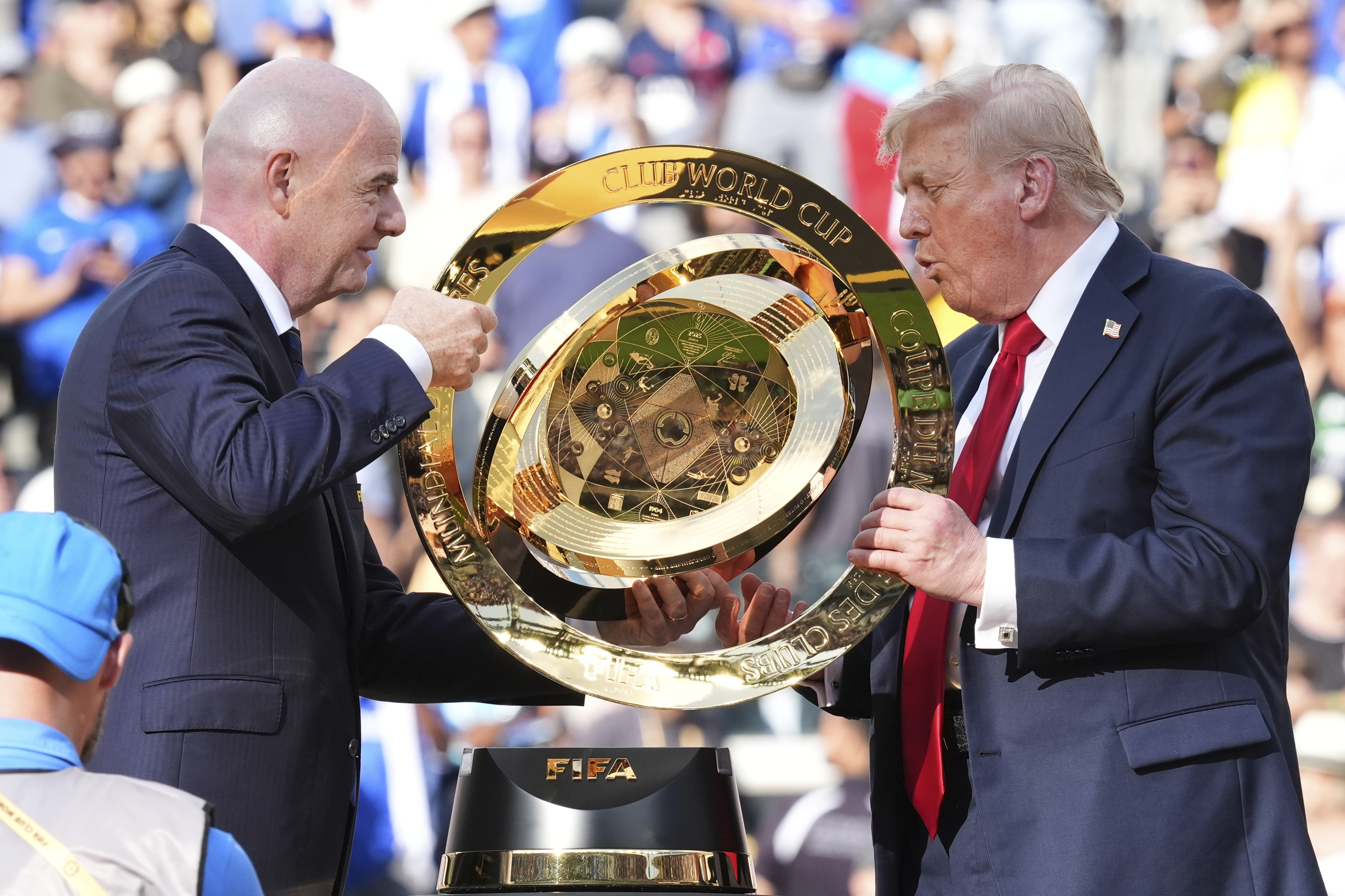 President Donald Trump, right, and FIFA President Gianni Infantino carry the championship trophy at the conclusion of the Club World Cup final soccer match at MetLife Stadium in East Rutherford, N.J., Sunday, July 13, 2025.
