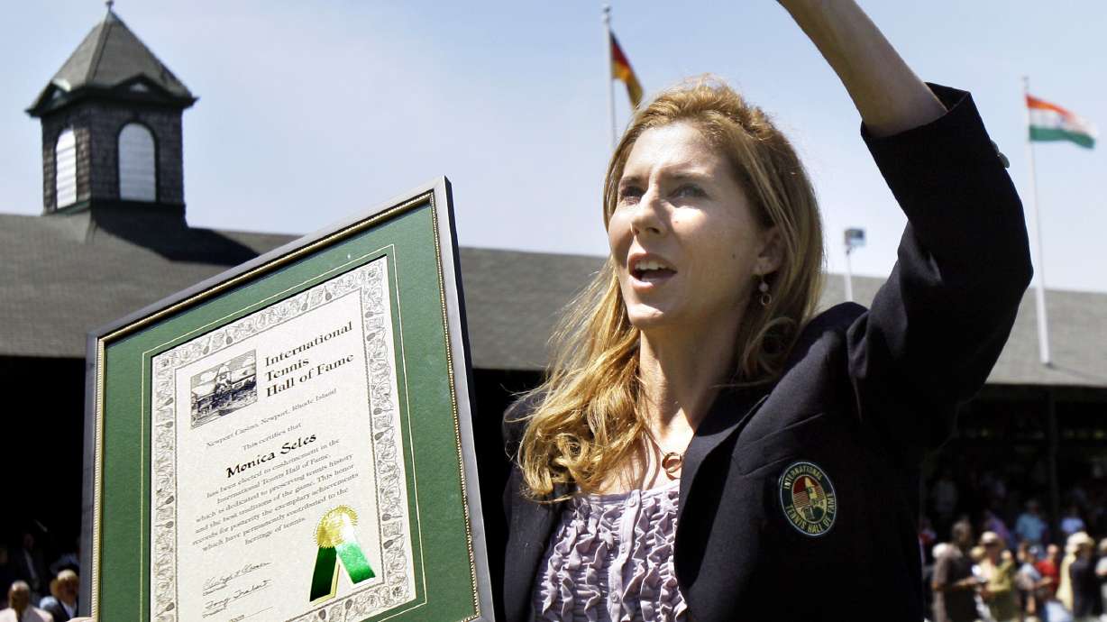 FILE - International Tennis Hall of Fame inductee Monica Seles waves to the crowd as she holds her plaque during ceremonies in Newport, R.I., July 11, 2009.