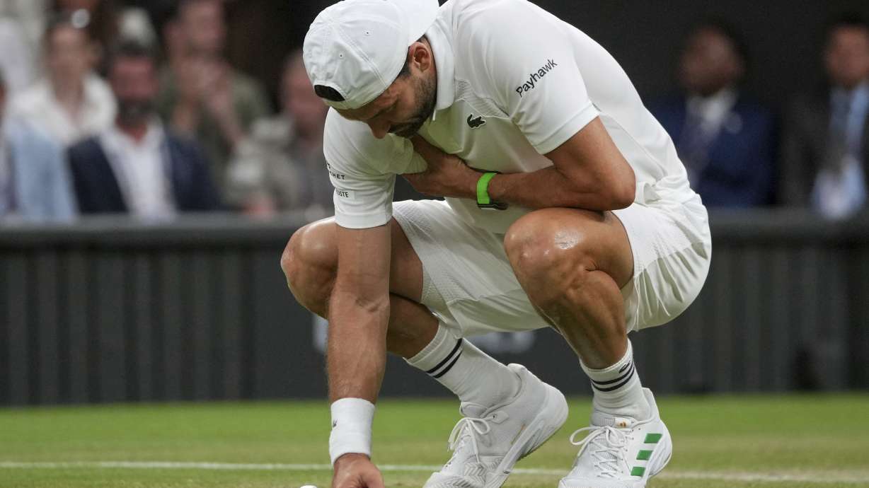 FILE - Bulgaria's Grigor Dimitrov clutches his chest with an injury which forced him to retire injured from a fourth round men's singles match against Italy's Jannik Sinner at the Wimbledon Tennis Championships in London, Monday, July 7, 2025.