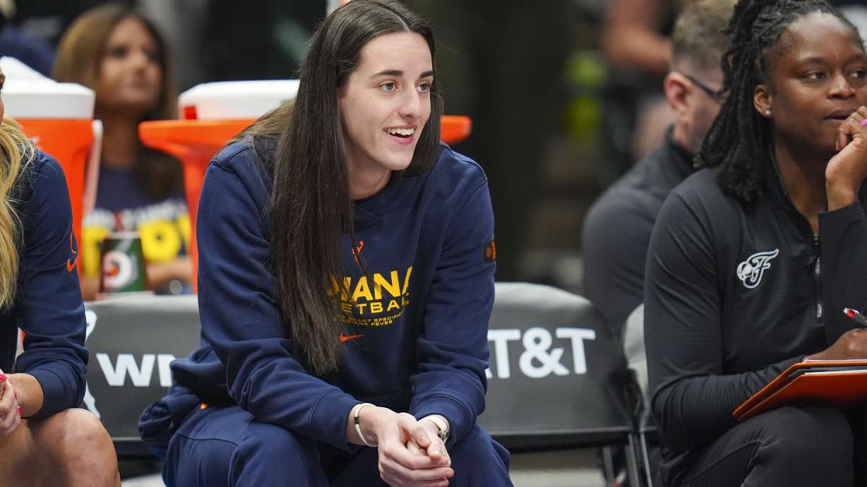 Indiana Fever guard Caitlin Clark looks on from the bench during the first half of a WNBA basketball game against the Dallas Wings Friday, Aug. 1, 2025, in Dallas.