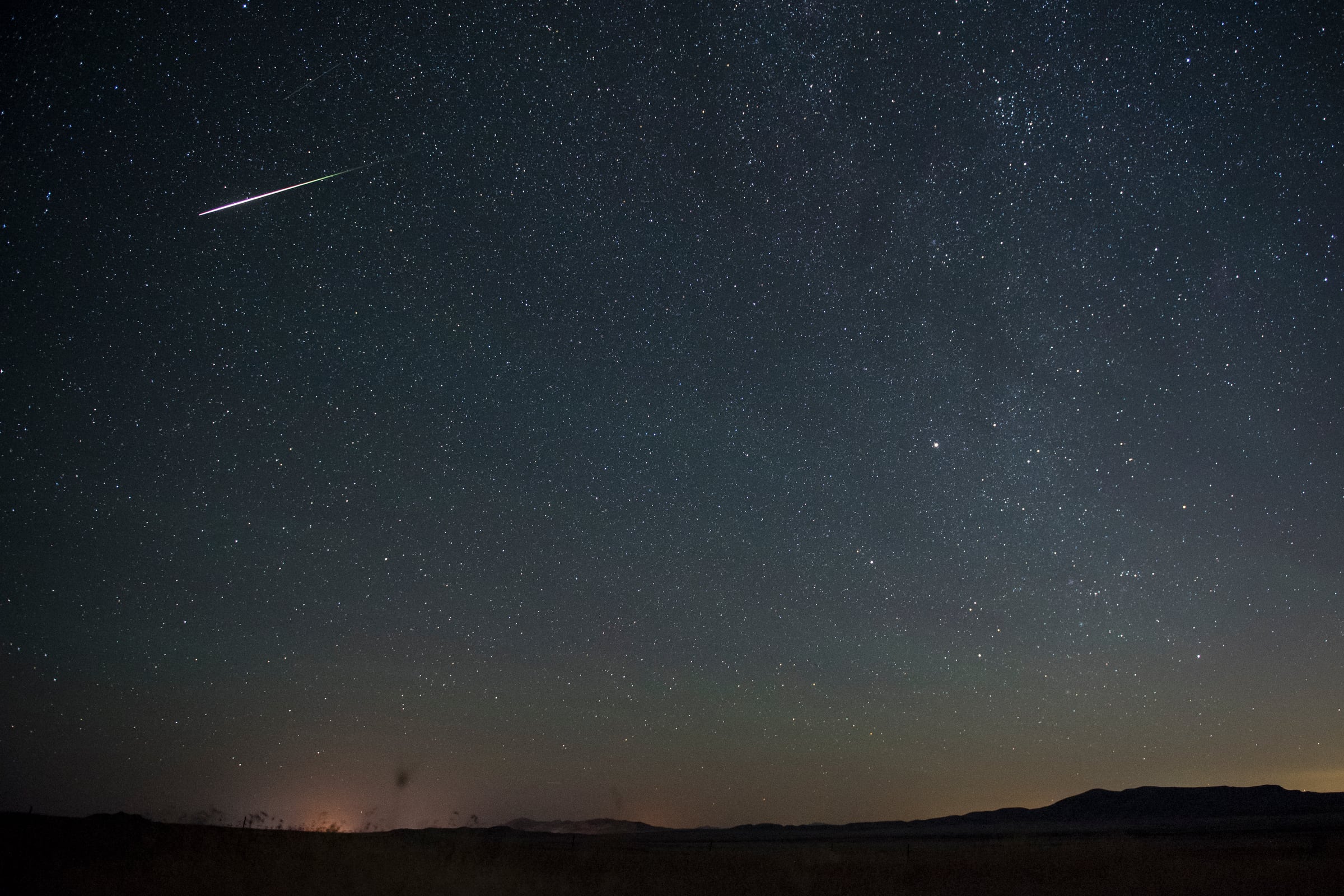A meteor streaks through the sky near the Grassy Mountains in Tooele County during the Perseid meteor shower, Aug. 12, 2016.