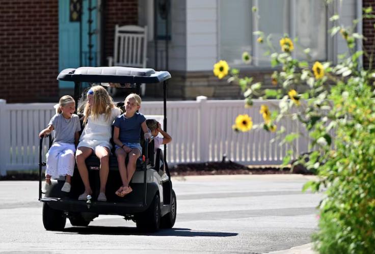 Goldie Johnson rides with cousins Olivia Healey and Winnifred Healey on the back of the Healey family golf cart driven by Lisa Healey after visiting a local Holiday for some treats with her daughters and a niece in Millcreek on Tuesday.
