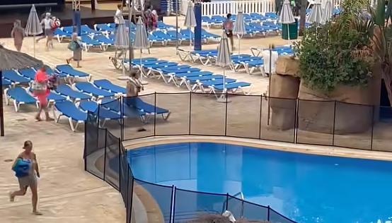 People run to get a chair at the pool at Benidorm in Alicante, Spain, on July 29, 2022.
