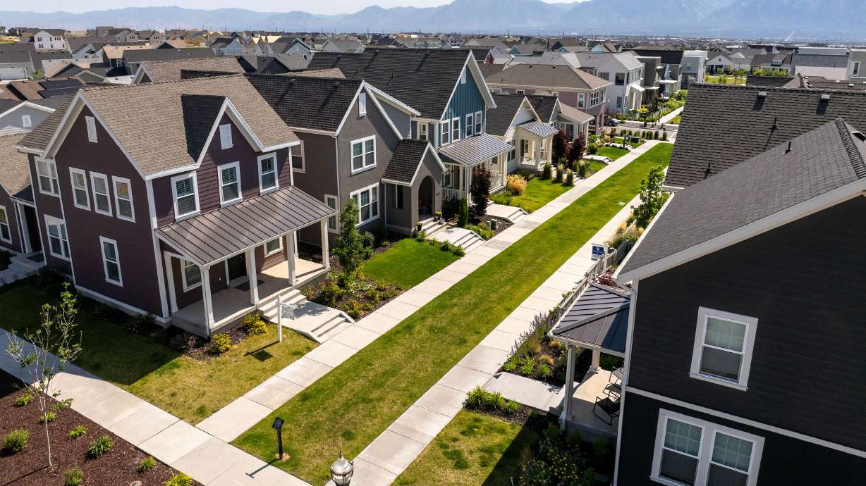 Two real estate signs are posted across from each other at homes in West Jordan on June 3. A new nationwide survey shows homebuyers are willing to trade safety from crime and natural disasters for affordability.