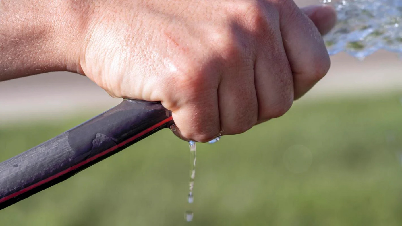 A man waters the lawn in Cedar City, May 26, 2023. City officials are asking residents to conserve water as aquifer levels continue to drop.