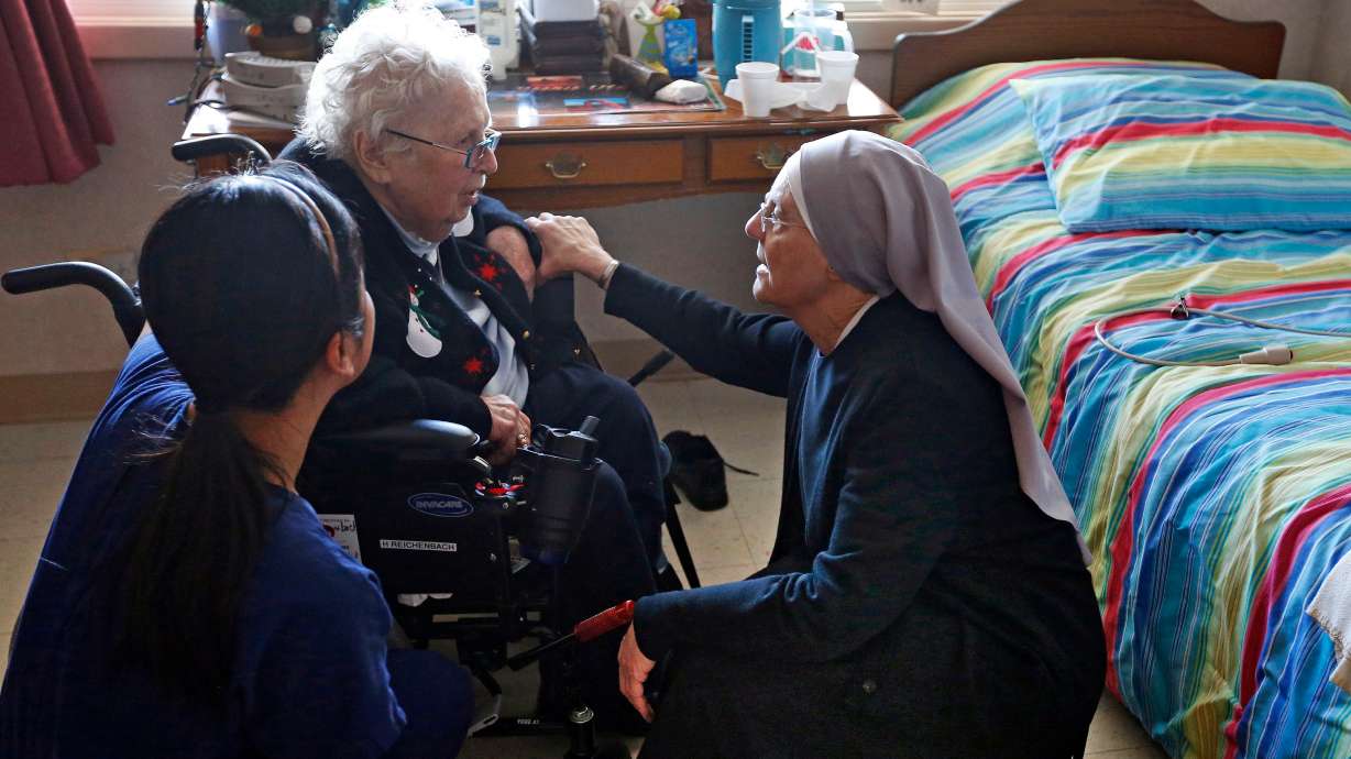 Mother Patricia Mary, right, and nurse Friary Nguyen visit 99-year-old resident Helen Reichenbach in her room at the Mullen Home for the Aged, run by Little Sisters of the Poor, Jan. 2, 2014.