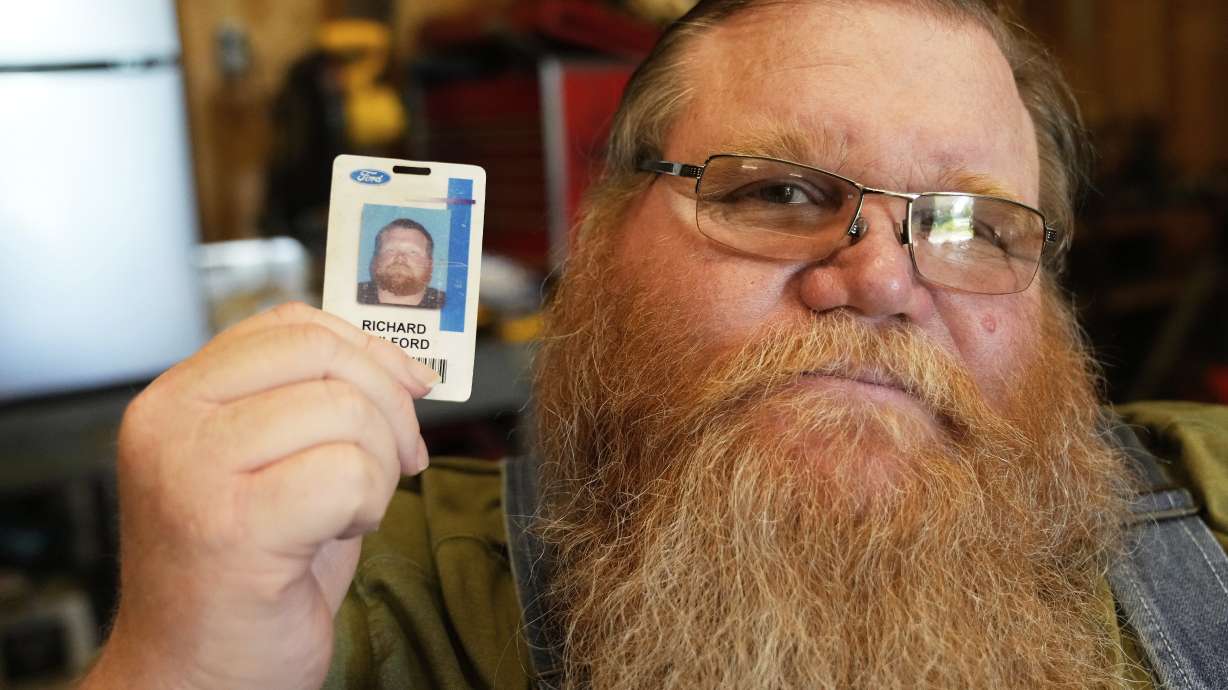Richard Guilford poses for a portrait on Thursday with an ID card from his recently recovered wallet that he lost 11 years ago, in Petersburg, Mich.