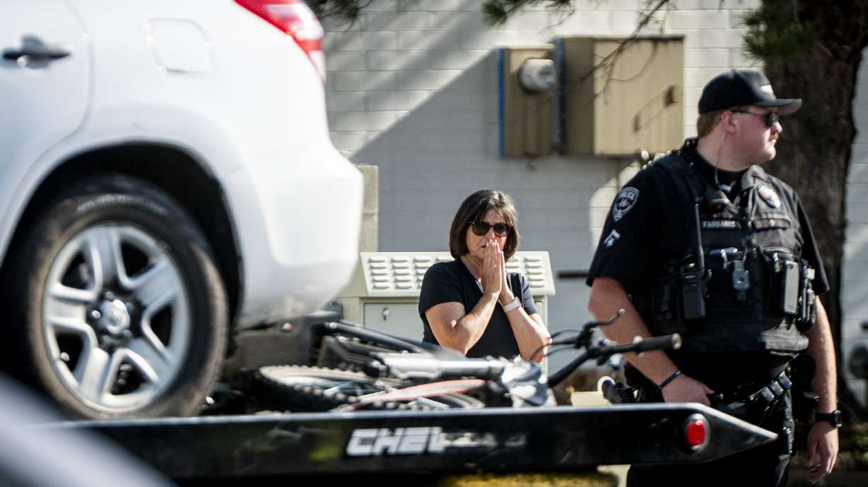 Carol Thomsen looks to an electric bike secured on a tow truck as Riverton and Herriman police and fire departments respond to a fatal auto and e-bike incident near the intersection of 1300 West and 12600 South in Riverton on Thursday.