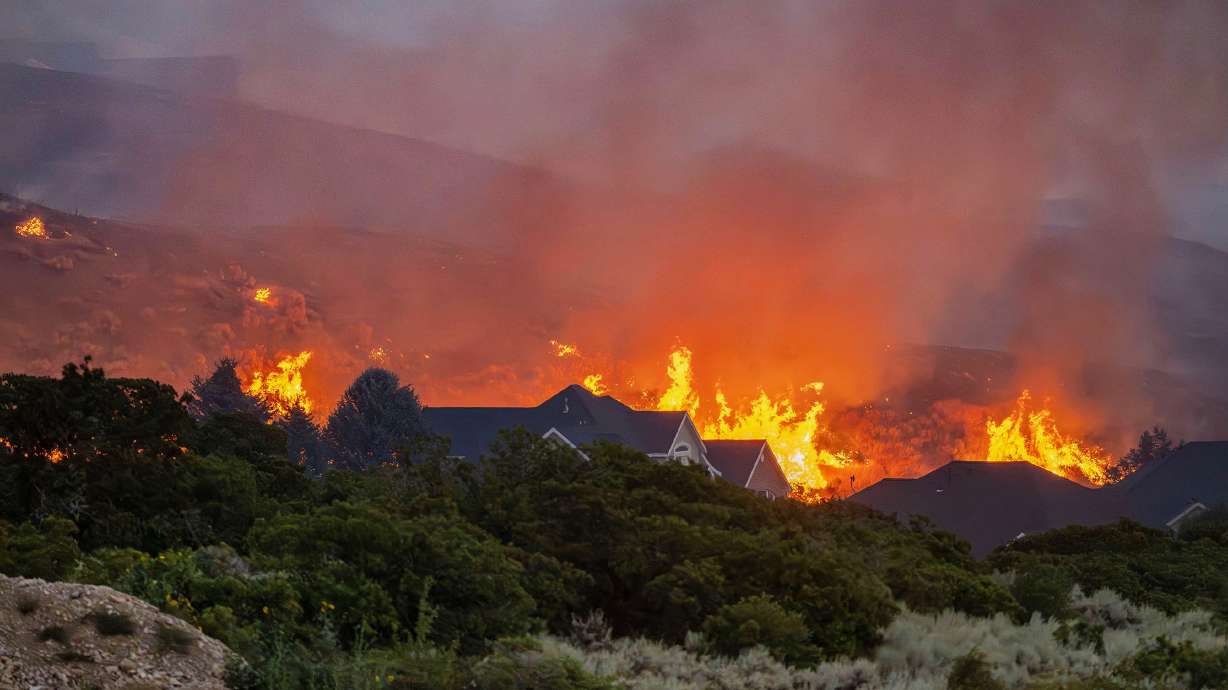 The Willard Peak Fire burns near homes and on the mountain in North Ogden on Wednesday.