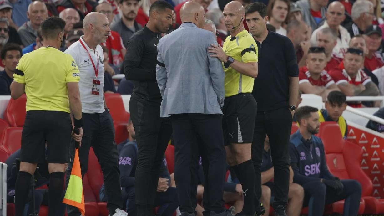 Liverpool's manager Arne Slot, centre, talks to the referee during the English Premier League soccer match between Liverpool and Bournemouth at Anfield stadium in Liverpool, England, Friday, Aug. 15, 2025.