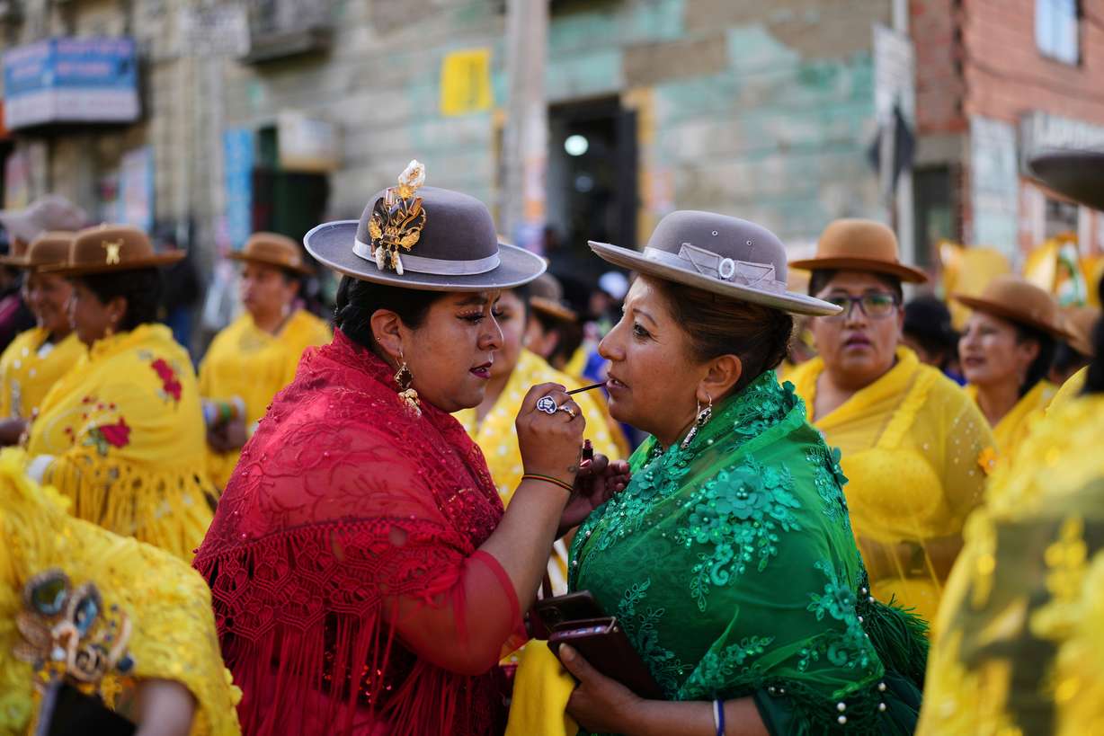 A supporter of Bolivian presidential candidate Samuel Doria Medina applies lipstick to another at an Aug. 12 rally in La Paz, Bolivia.