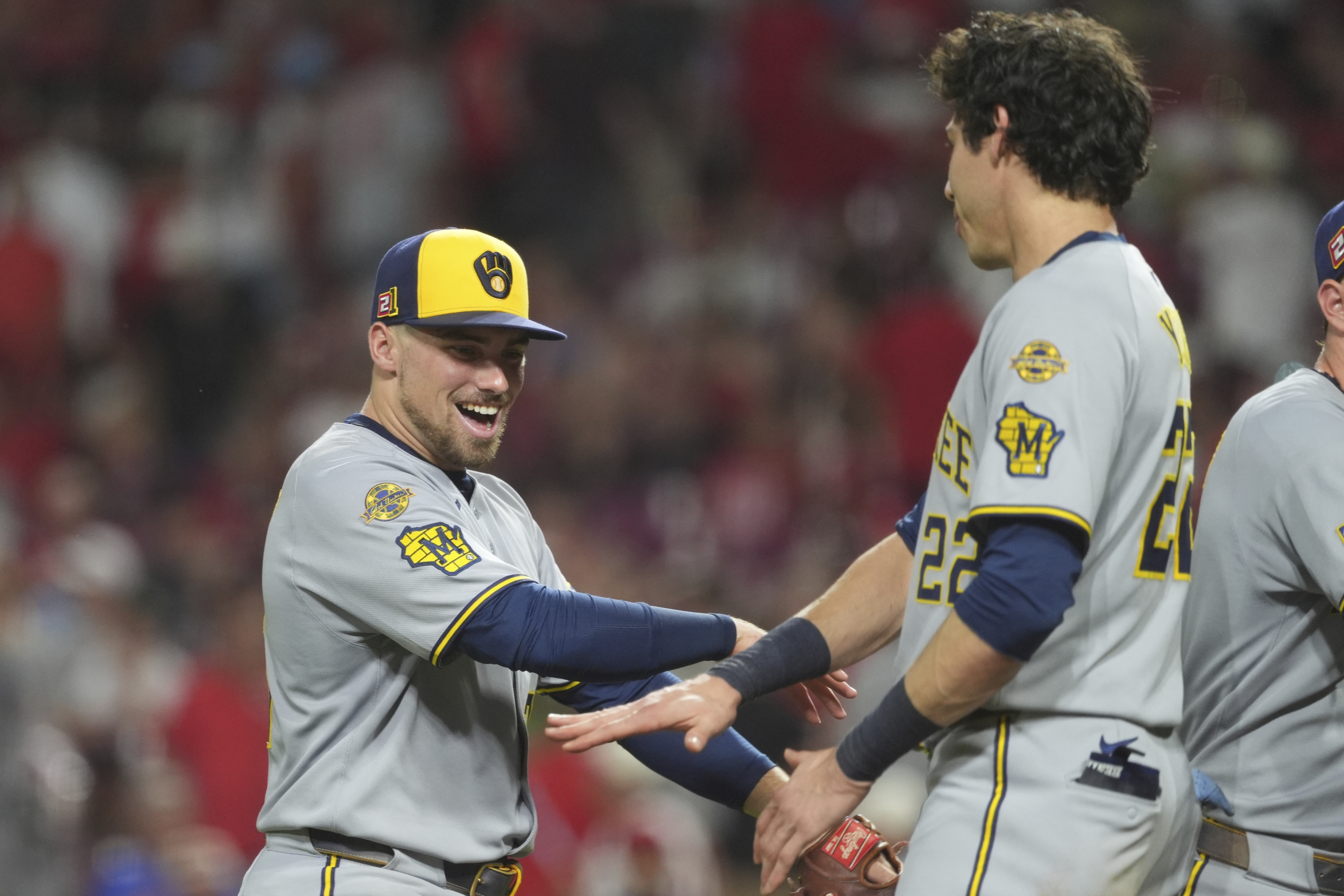 Milwaukee Brewers' Caleb Durbin, left, and Milwaukee Brewers' Christian Yelich, right, celebrate at the conclusion of a baseball game game against the Cincinnati Reds, Friday, Aug. 15, 2025, in Cincinnati.