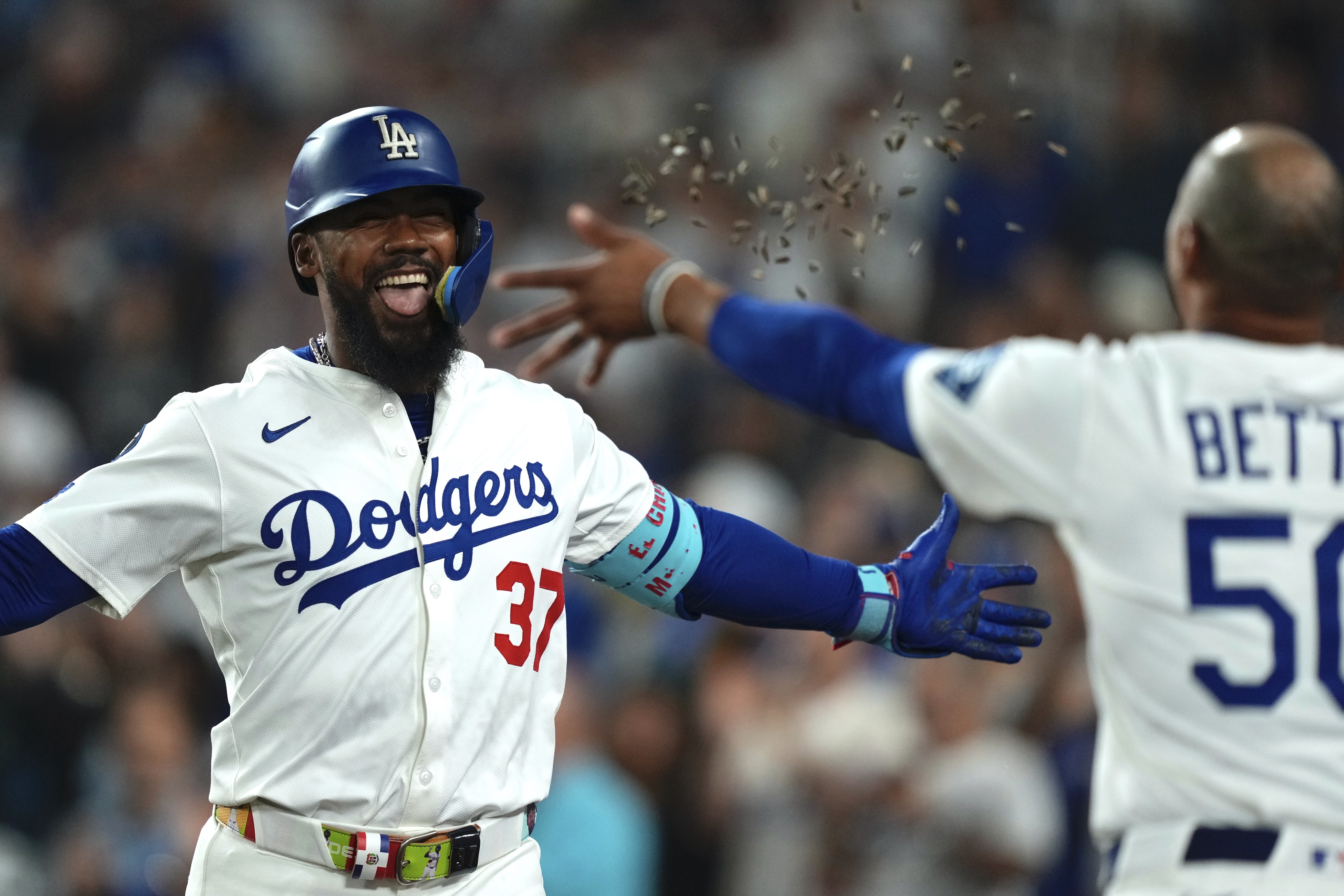 Los Angeles Dodgers' Teoscar Hernández, left, is hit with seeds thrown by Mookie Betts after hitting a solo home run during the seventh inning of a baseball game against the San Diego Padres, Friday, Aug. 15, 2025, in Los Angeles. 