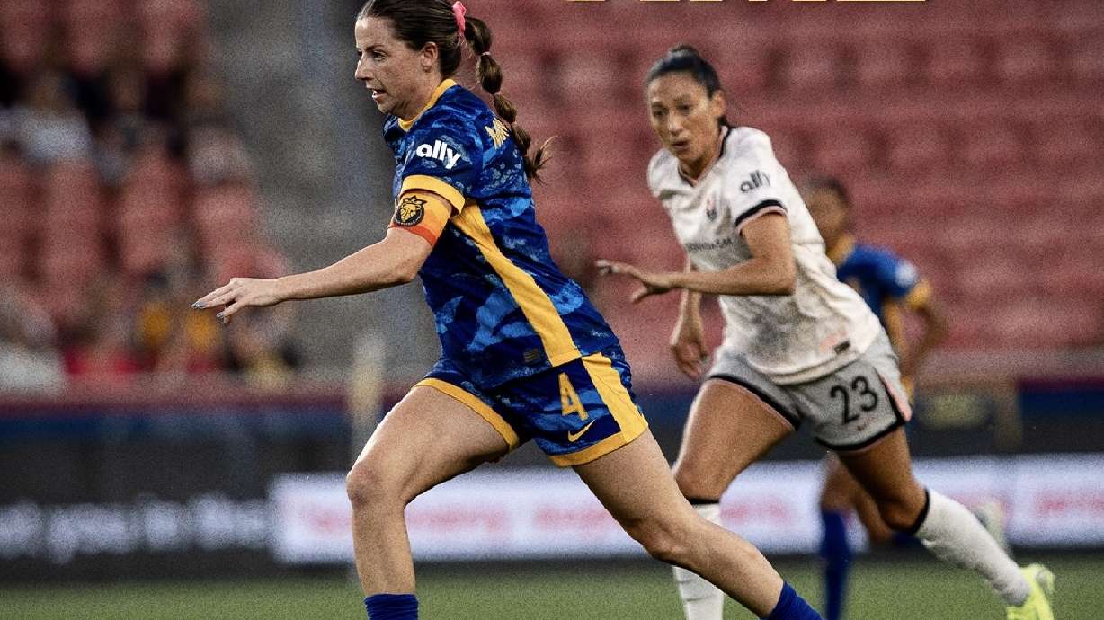 Utah captain Paige Monaghan, left, dribbles away from Angel City's Christen Press, right.