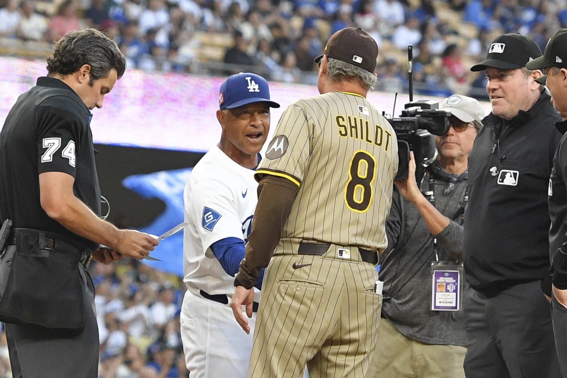 Los Angeles Dodgers manager Dave Roberts, second from left, greets San Diego Padres manager Mike Shildt prior to a baseball game Friday, Aug. 15, 2025, in Los Angeles. 