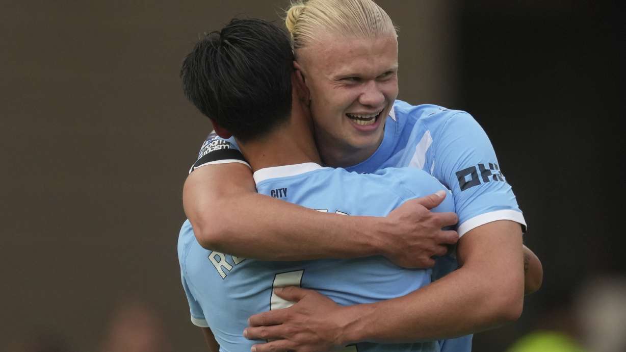 Manchester City's Erling Haaland, right, celebrates with Manchester City's Tijjani Reijnders after scoring his sides third goal during the English Premier League soccer match between Wolverhampton Wanderers and Manchester City at Molineux Stadium, Wolverhampton, England, Saturday, Aug. 16, 2025.