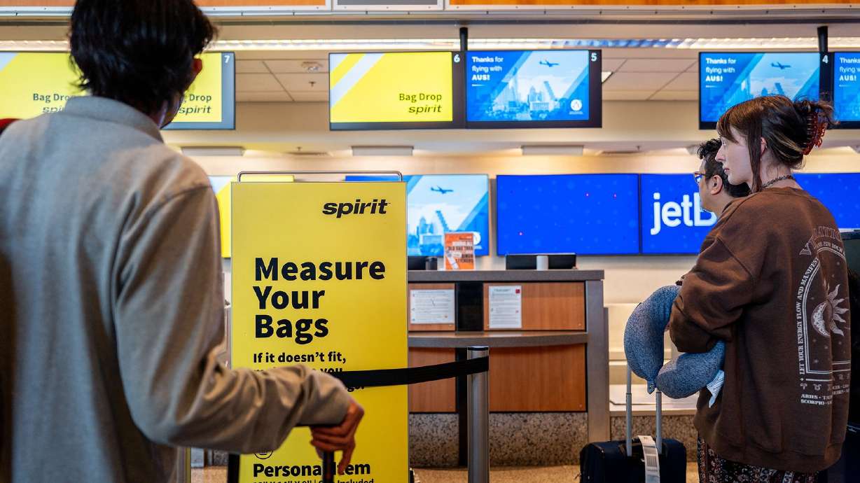 Customers wait in line to drop baggage off at a Spirit Airlines check-in counter in Austin, Texas. A federal judge blocked a proposed deal to have JetBlue buy Spirit Airlines in early 2024, saying it would hurt consumers by raising air fares.