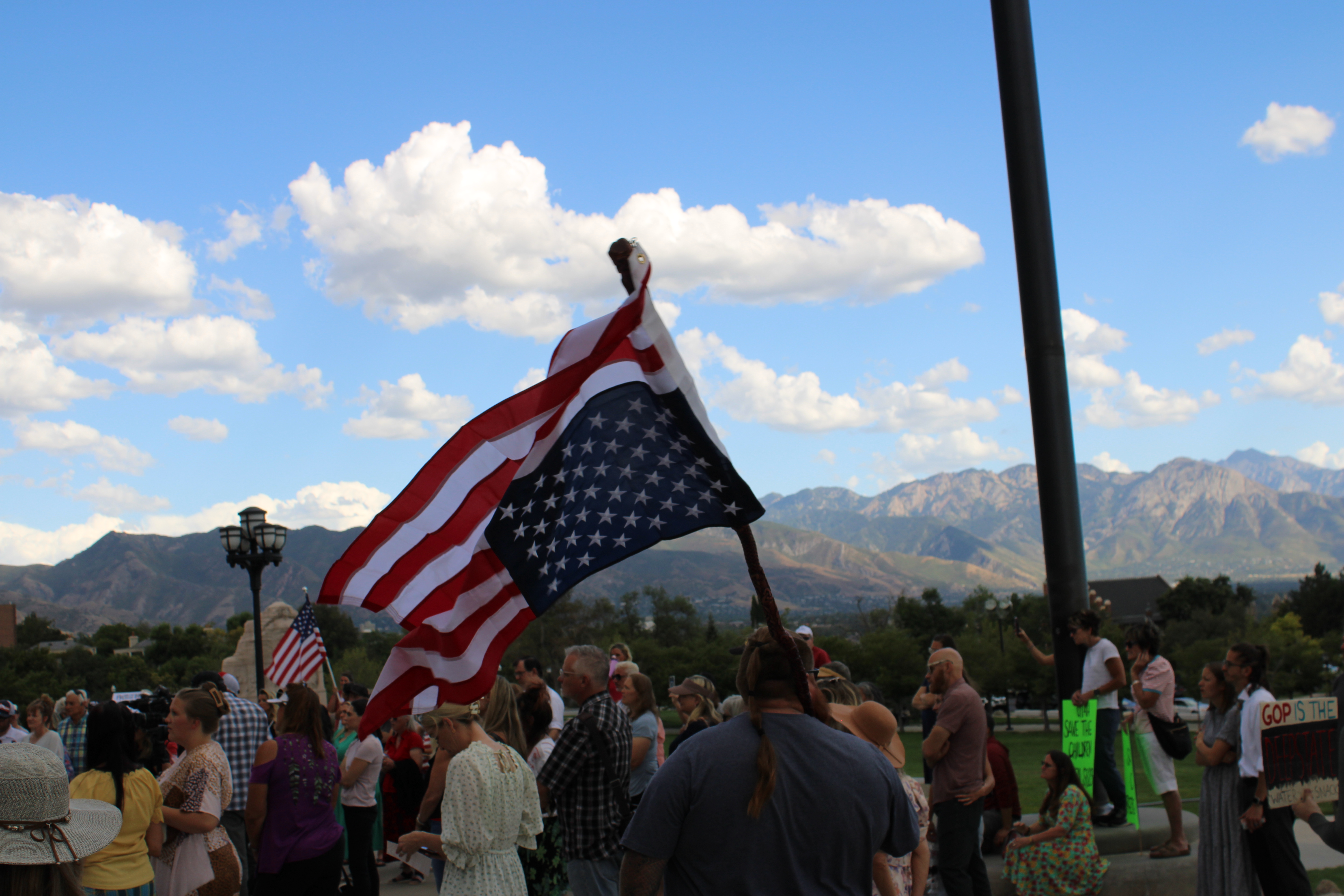A man carries an upside-down U.S. flag at a rally at the Capitol in Salt Lake City on Sunday.