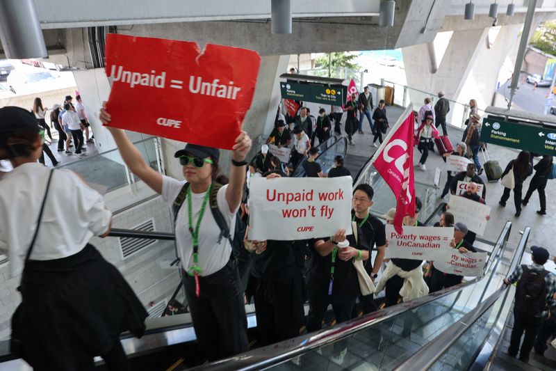 Demonstrators display placards while riding an escalator as Air Canada flight attendants said they will remain on strike and challenge a return-to-work order they called unconstitutional, in Richmond, British Columbia, Canada, Sunday. 