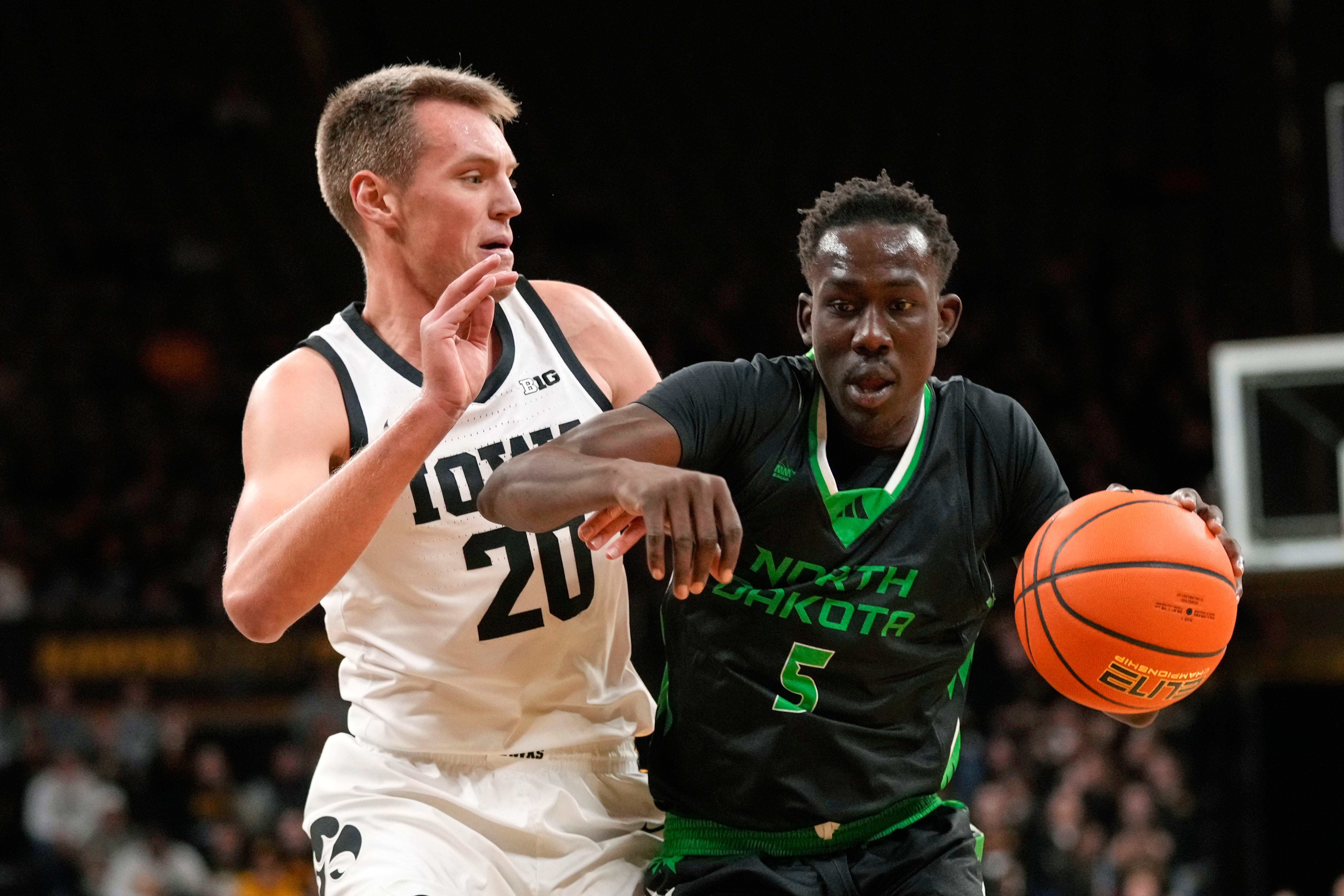 FILE - North Dakota forward Deng Mayar (5) drives past Iowa forward Payton Sandfort (20) during the first half of an NCAA college basketball game, Nov. 7, 2023, in Iowa City, Iowa. 