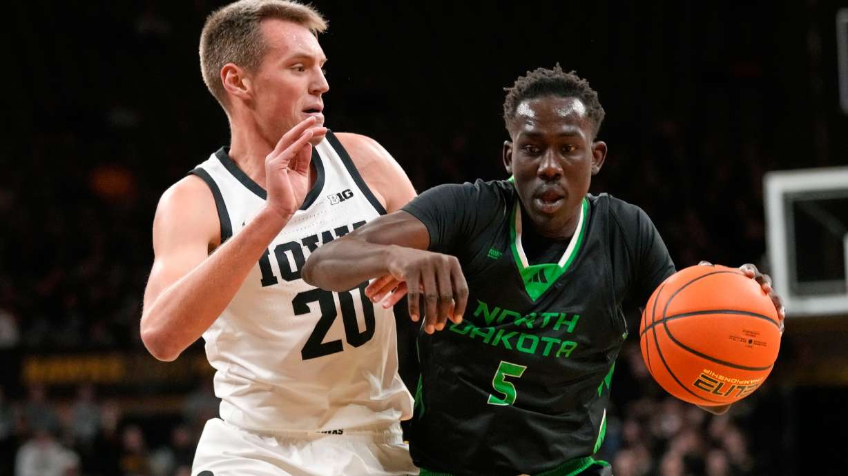 FILE - North Dakota forward Deng Mayar (5) drives past Iowa forward Payton Sandfort (20) during the first half of an NCAA college basketball game, Nov. 7, 2023, in Iowa City, Iowa.